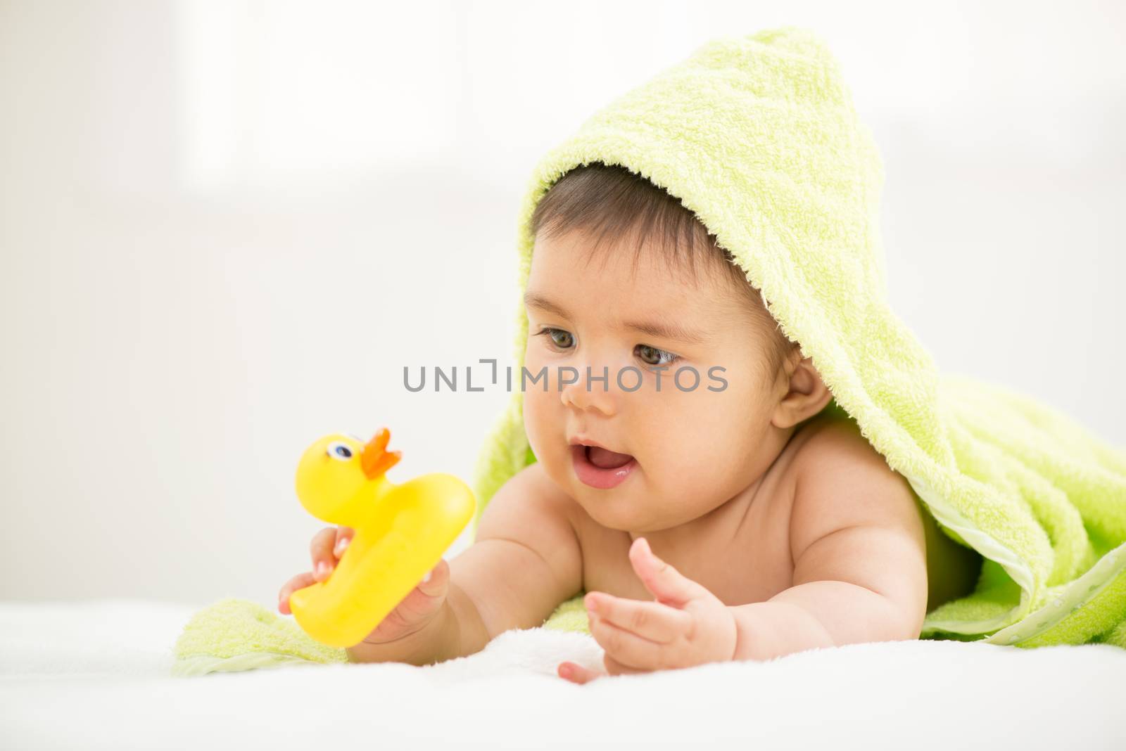 Cute baby boy lying under a towel