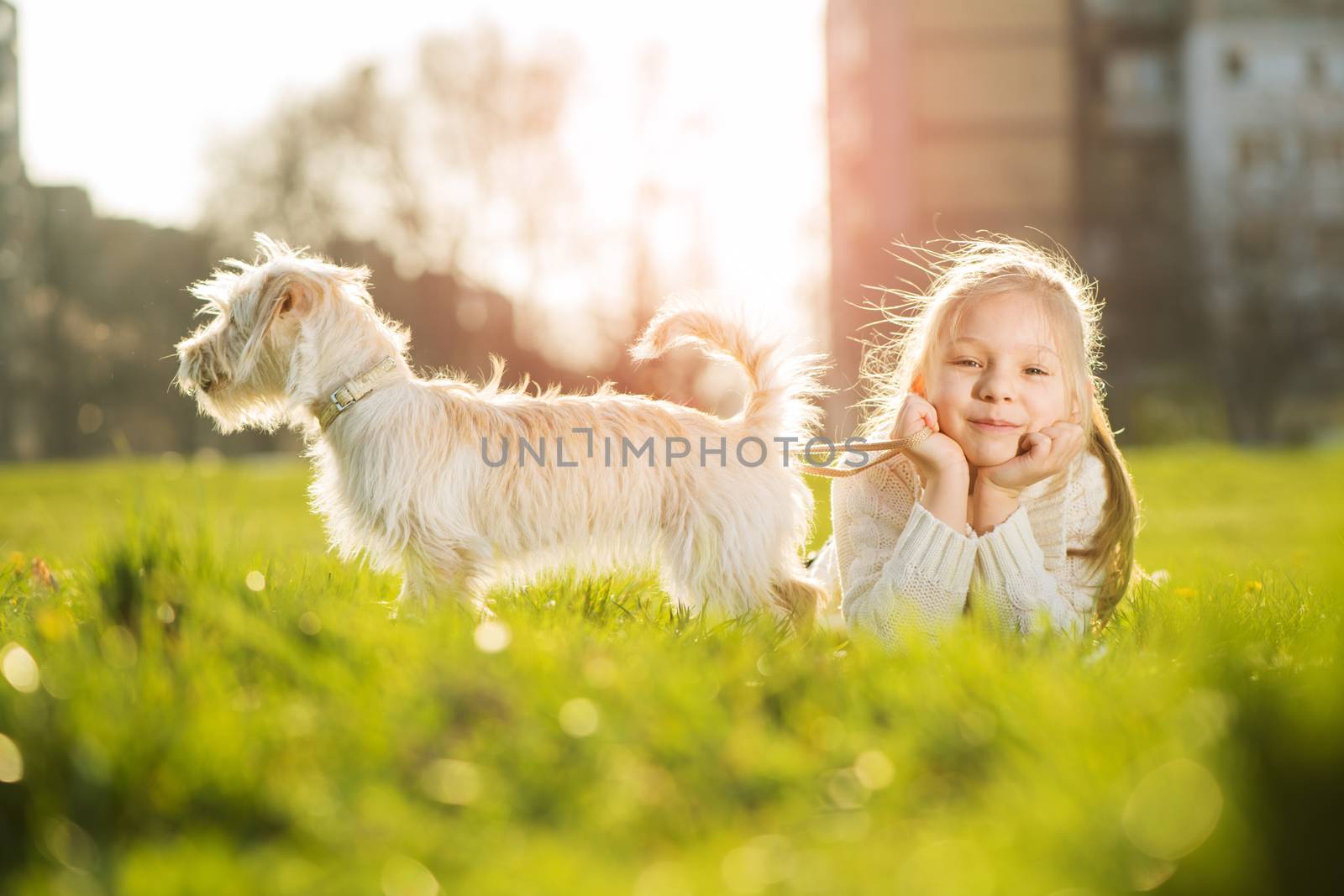 Little girl relaxing with her puppy dog in the park