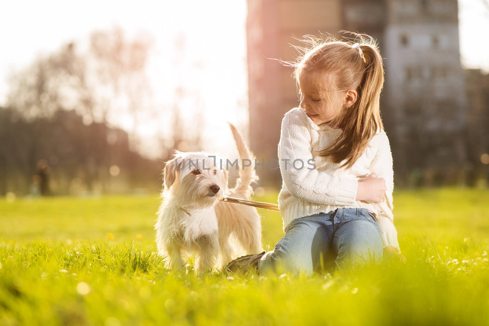 Little girl relaxing with her puppy dog in the park