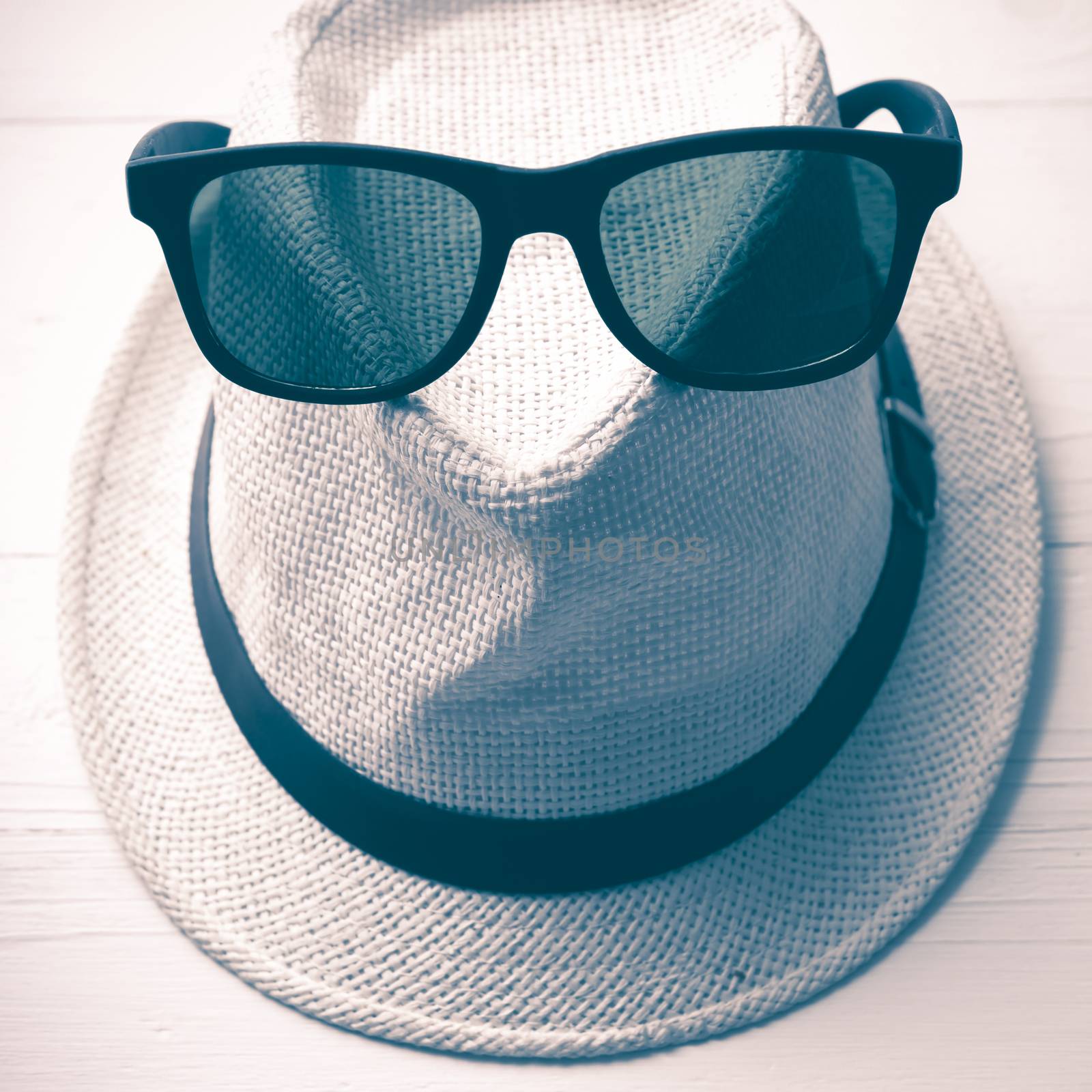 hat and sunglasses on white table vintage style