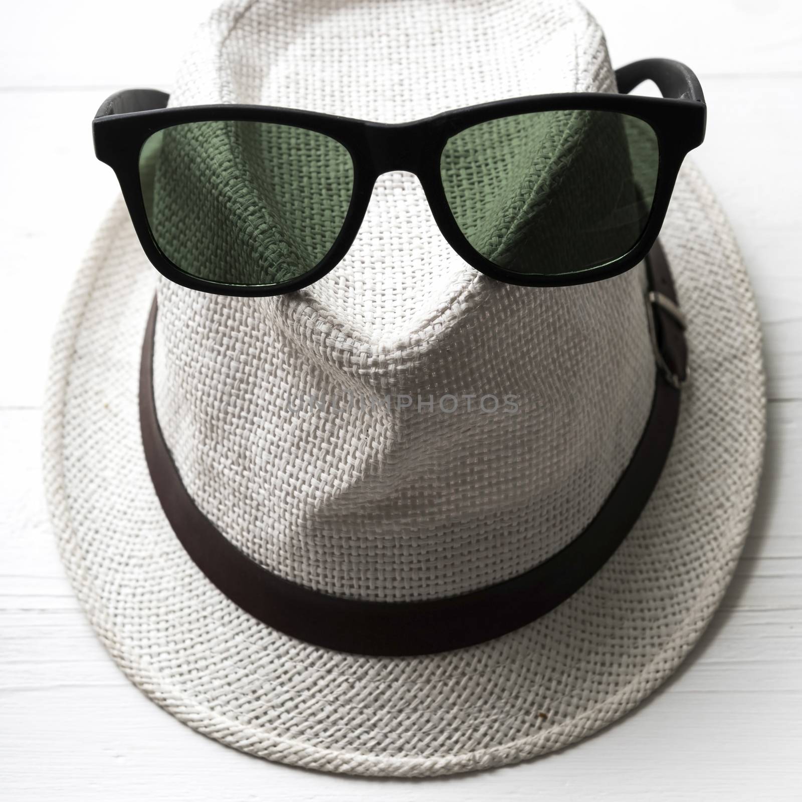 hat and sunglasses on white table