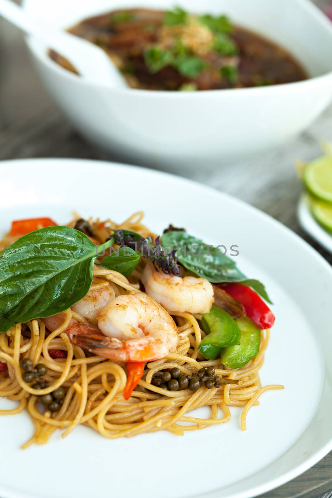 Thai food dishes with shrimp and noodles and soup with duck.  Shallow depth of field. 