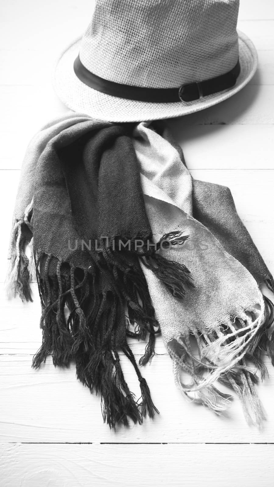 hat and blue scarf on white table black and white color