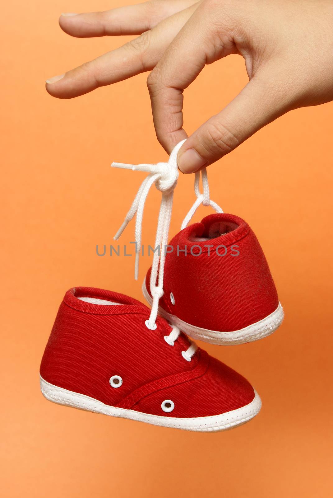 A mother holds on to a pair of baby shoes.