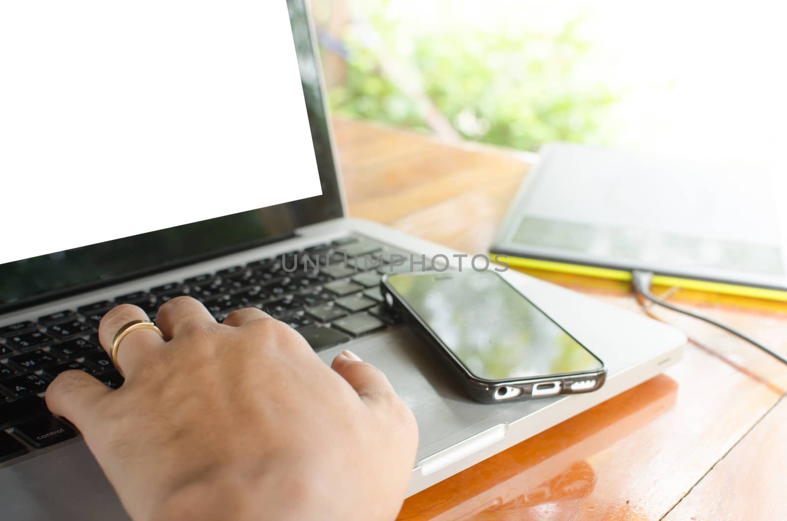 Close up of business woman hand working on laptop computer on wooden desk as concept with overcast effect