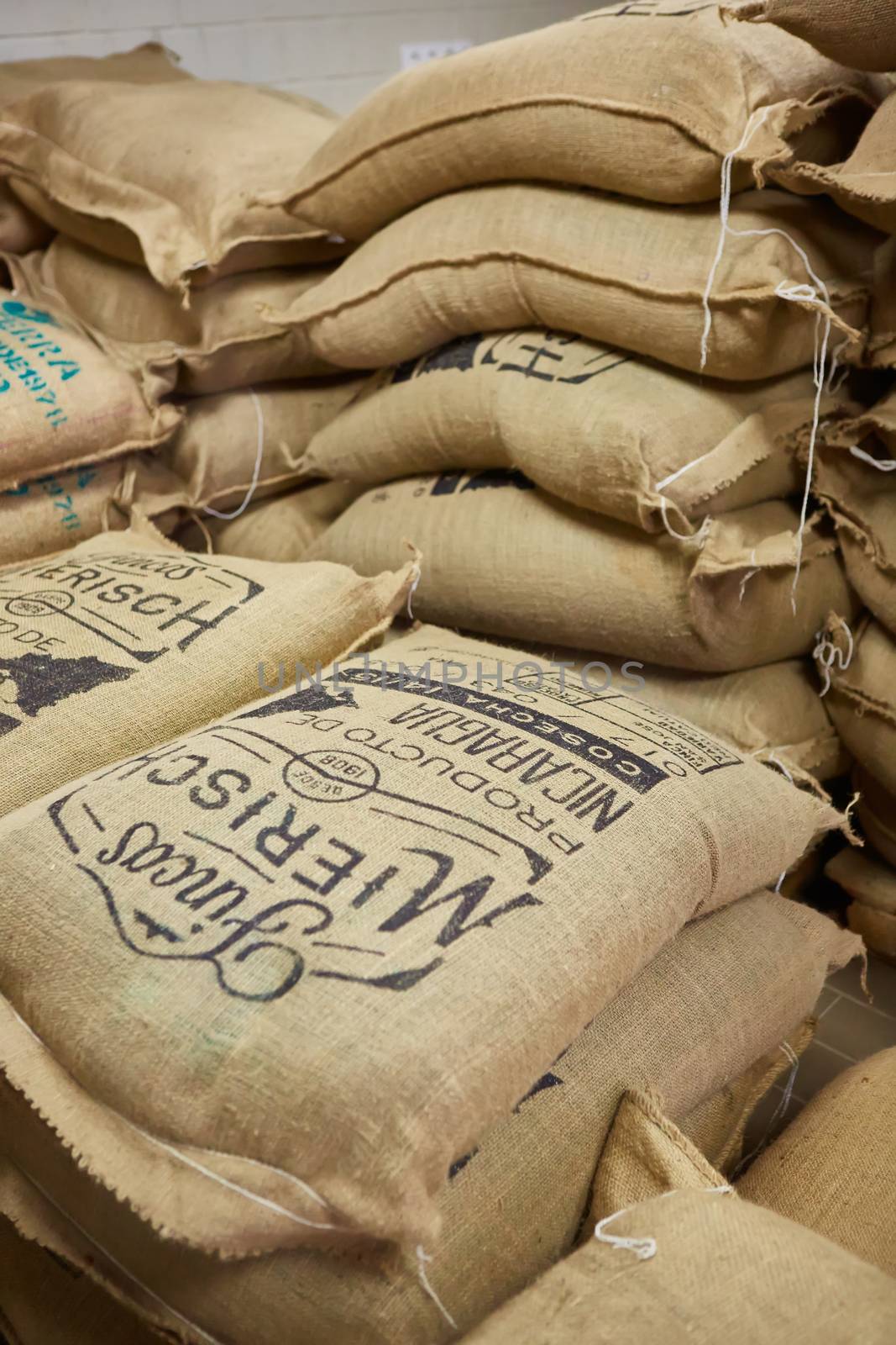 stack of burlap sacks with coffee beans at warehouse