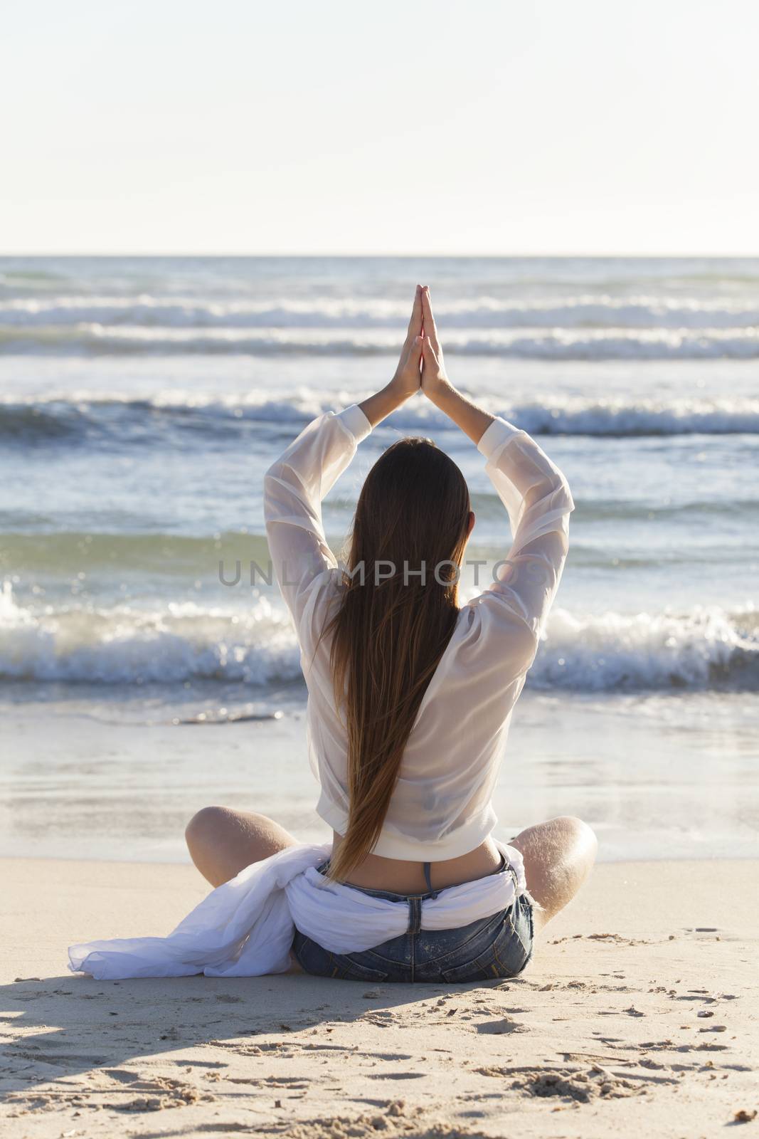 woman doing yoga on the beach by bernjuer