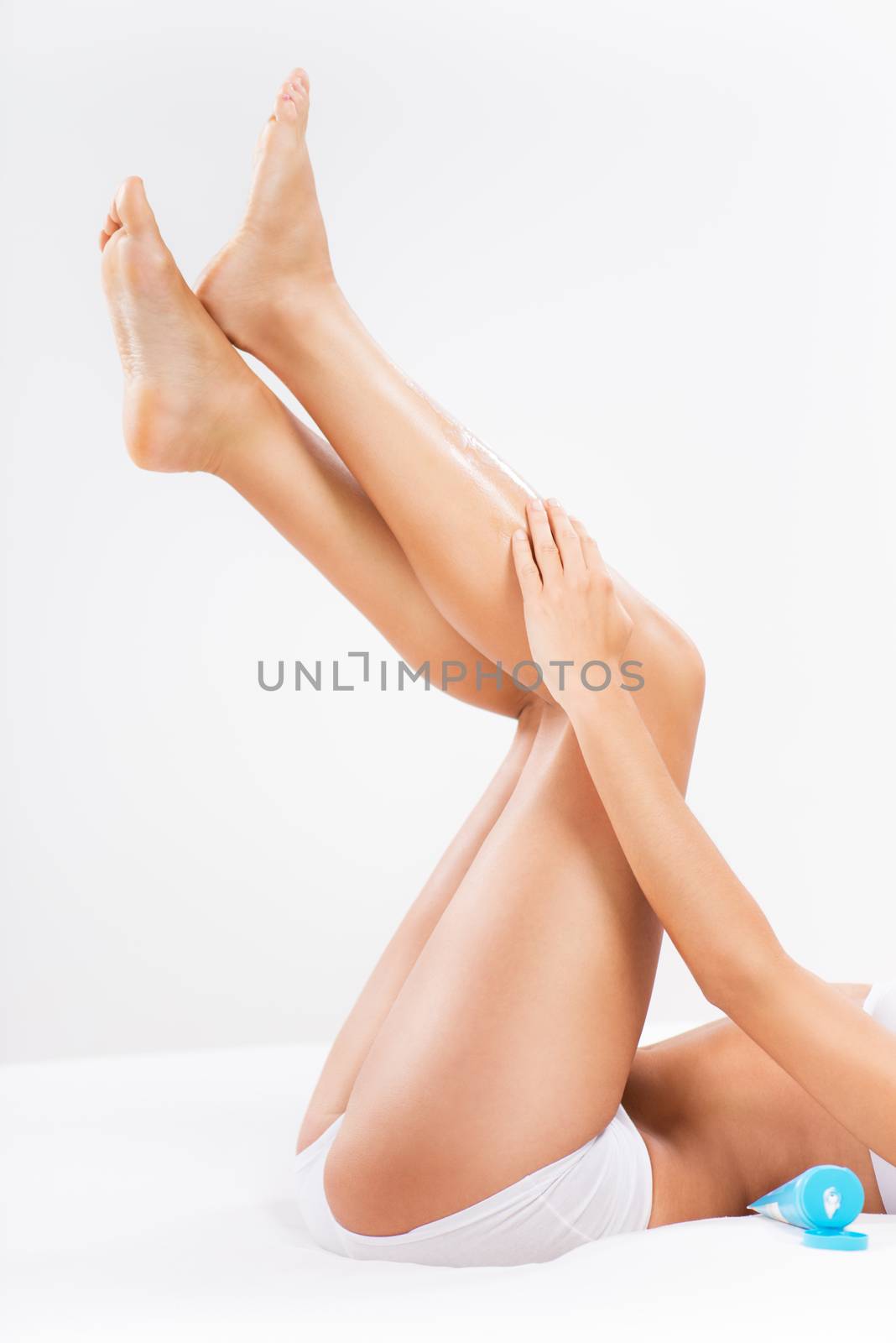 Bodycare of female Smooth legs with a body lotion.