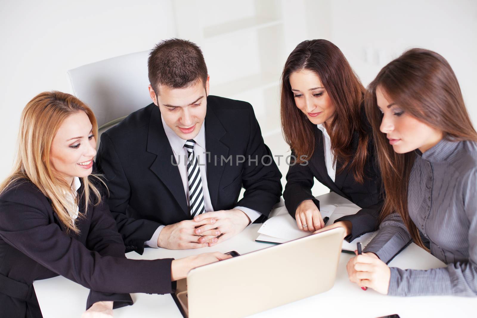 Four happy Business people looking project at laptop in the office.