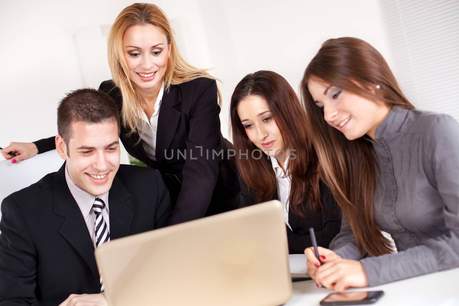 Happy Business woman showing her colleagues project at laptop in the office.