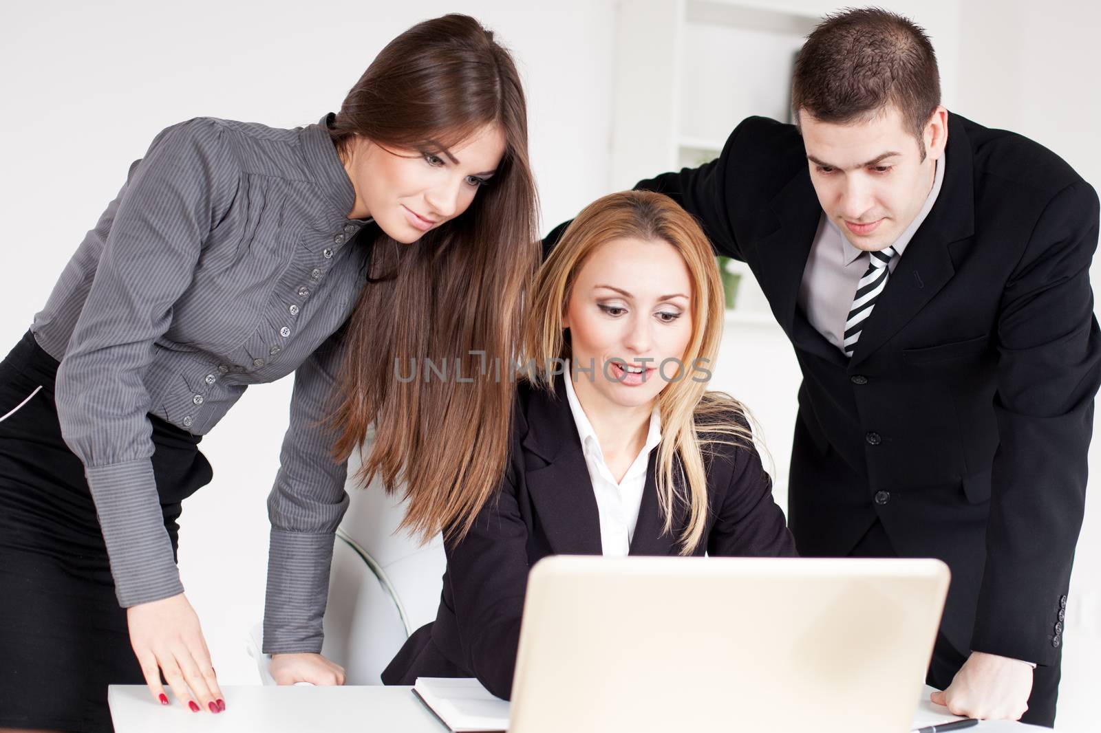 Happy Business woman showing her colleagues project at laptop in the office.