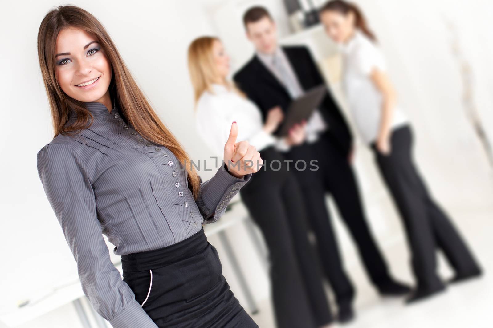 Happy Businesswoman showing thumbs up in the office. Looking at camera. Selective Focus.