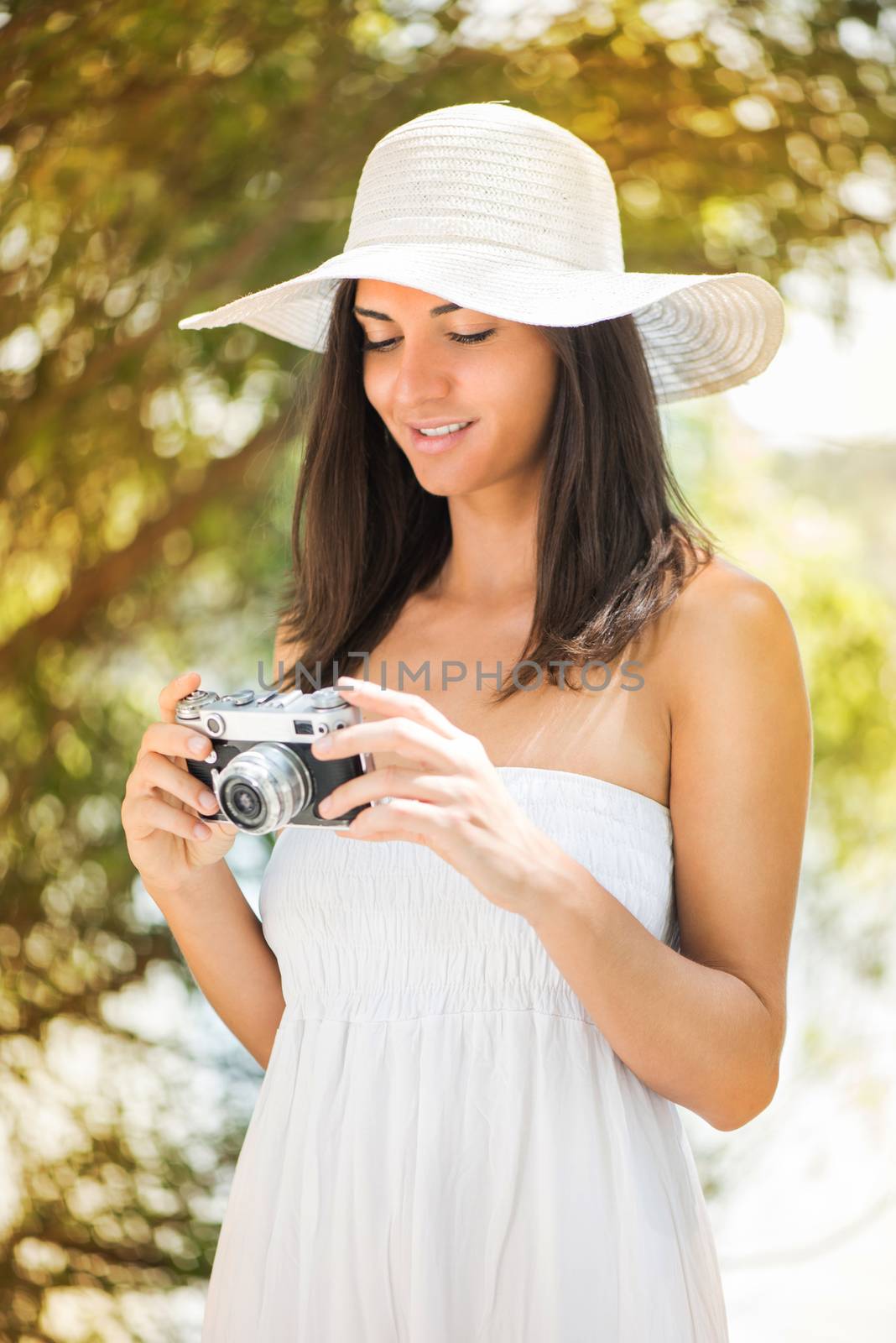 Young beautiful woman in the nature with retro photo camera.