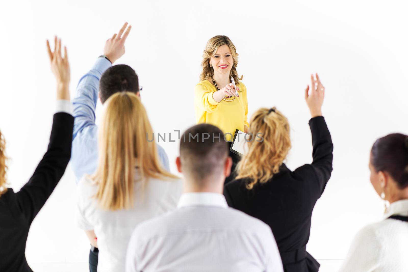 Friendly business woman explaining plan of work and answering the question. The team is listening and asking the questions.