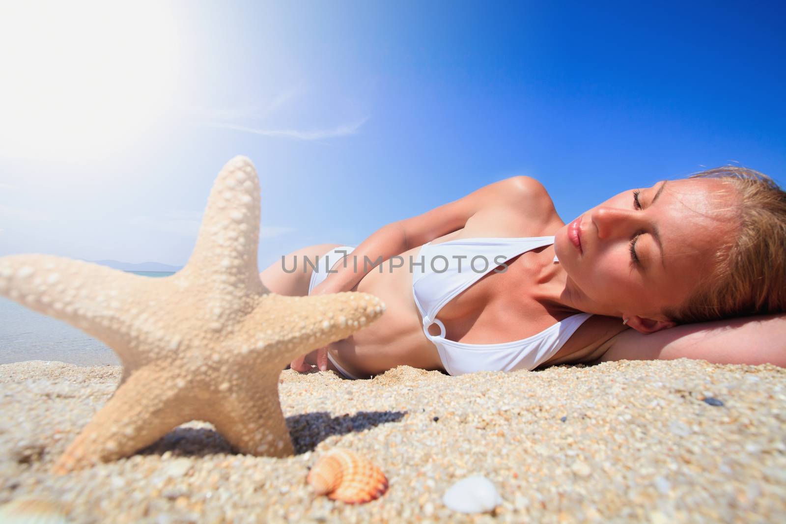 Starfish and beautiful young woman on the beach