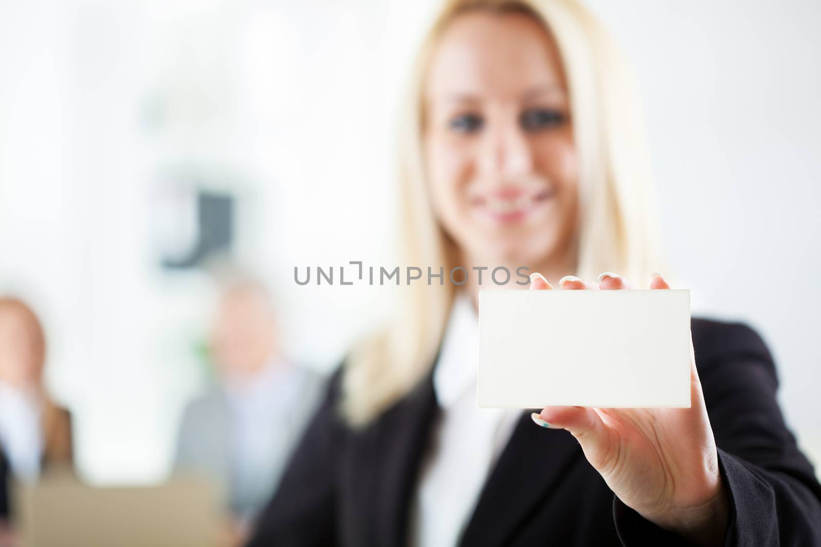 Beautiful young businesswoman holding Blank business card in the office. Looking at camera. Selective Focus.