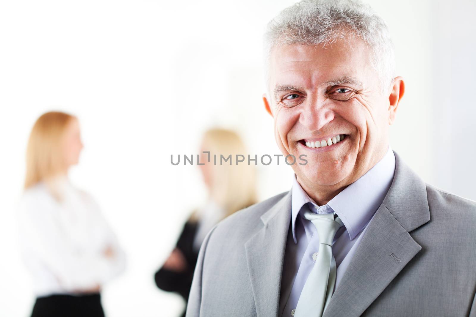 Happy senior businessman in the office. Looking at camera. Selective Focus.