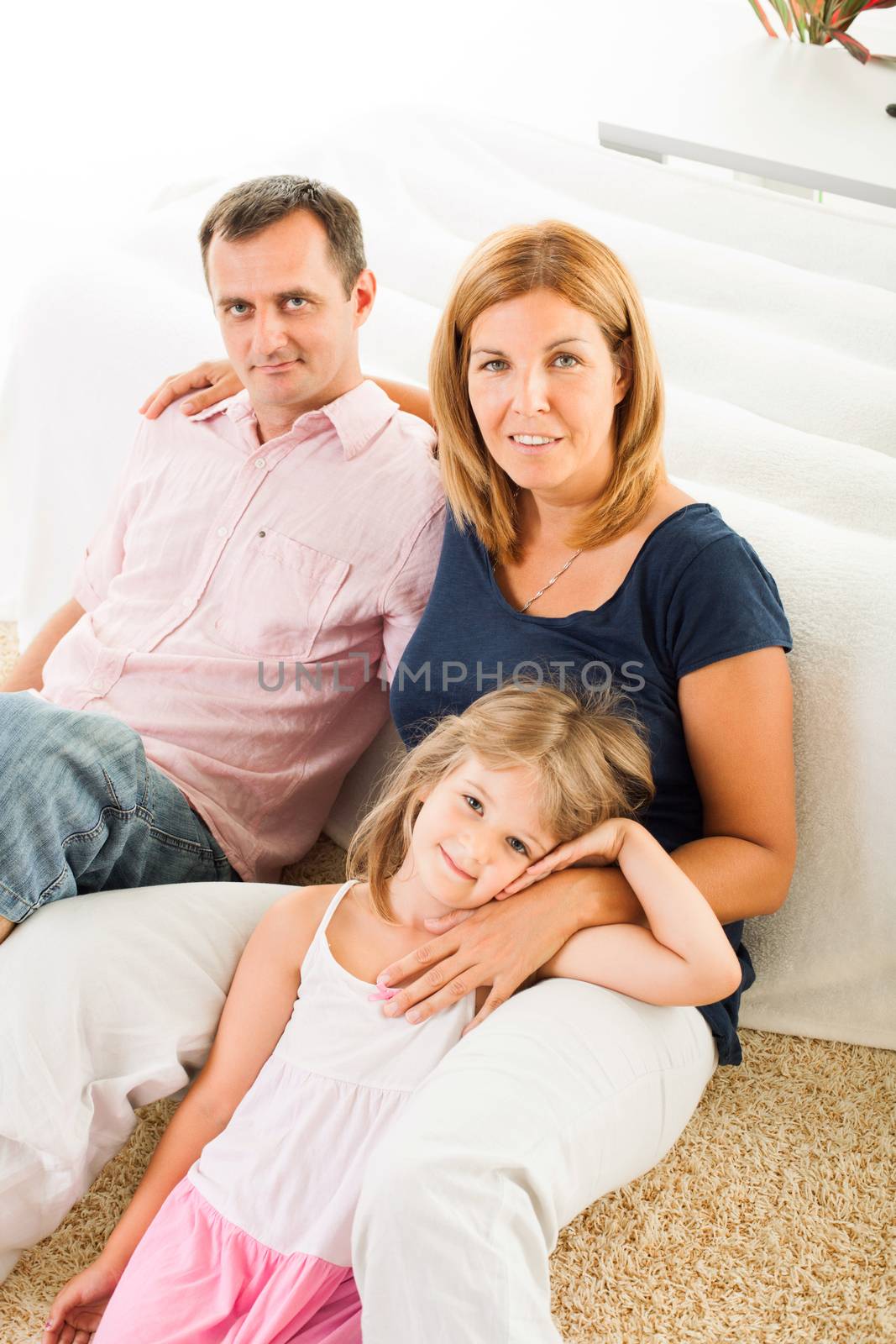 Beautiful happy family sitting on the carpet