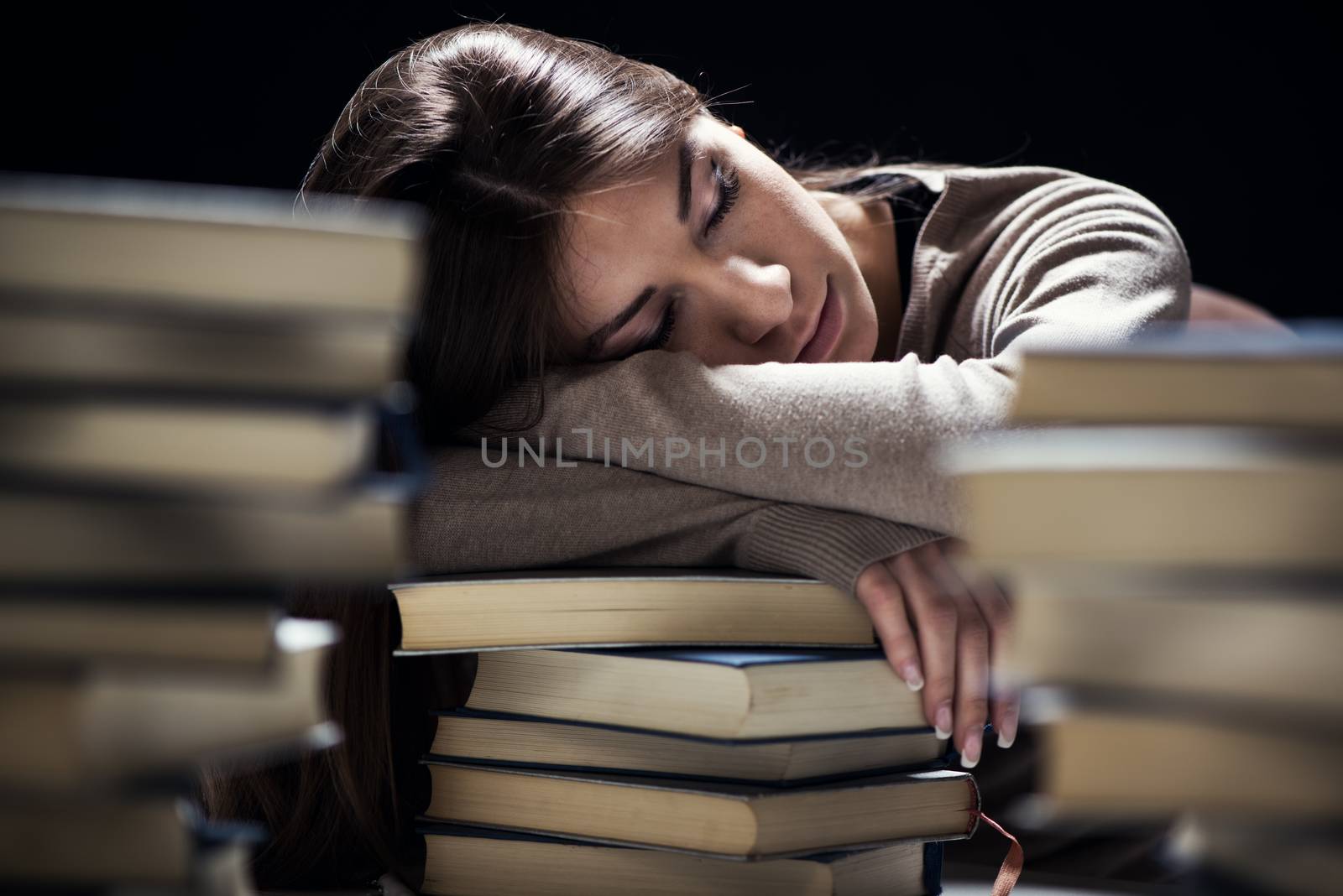 Tired student fell a sleep between many books, while learning. Selective focus.