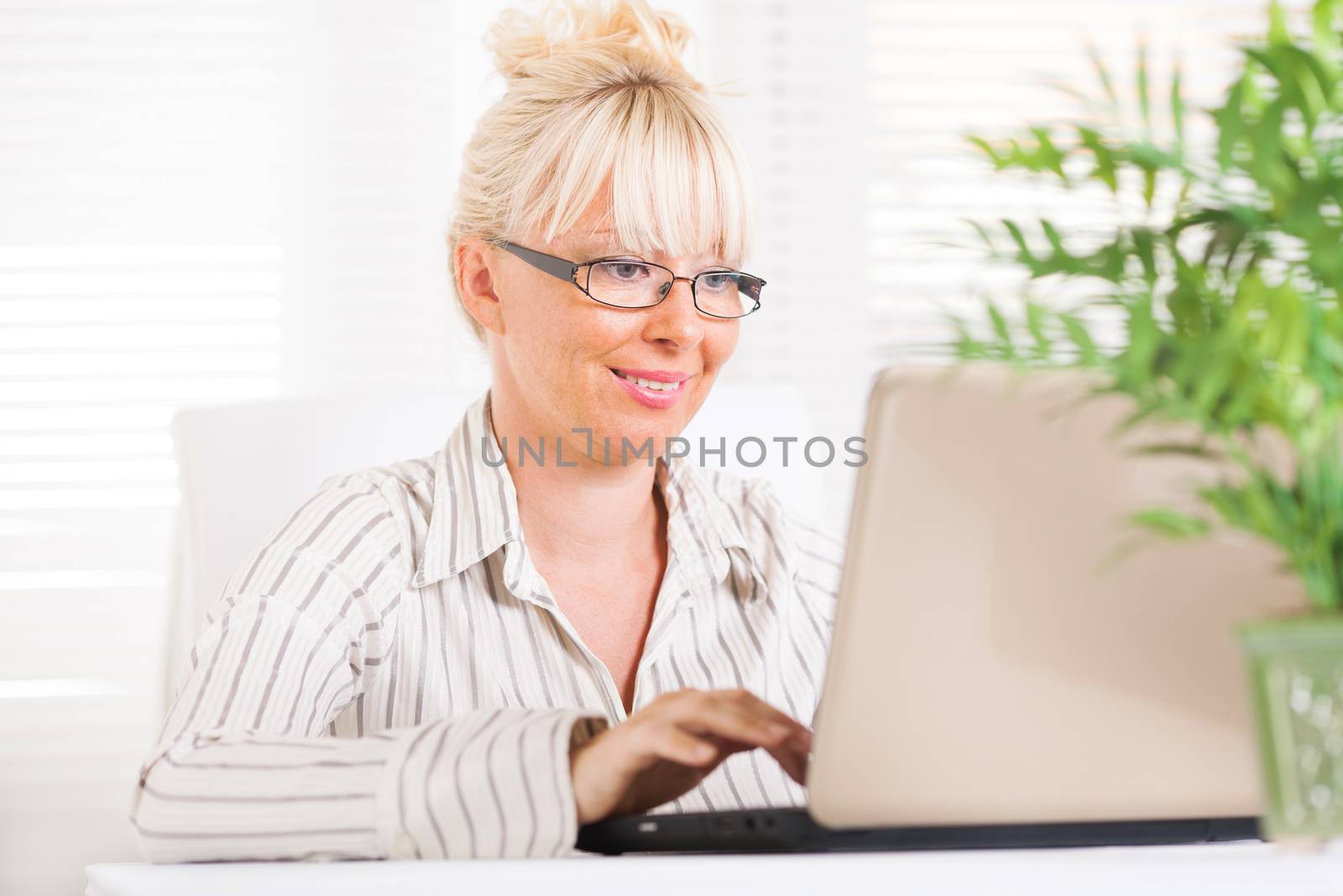 Beautiful mature Business woman working at laptop in the office