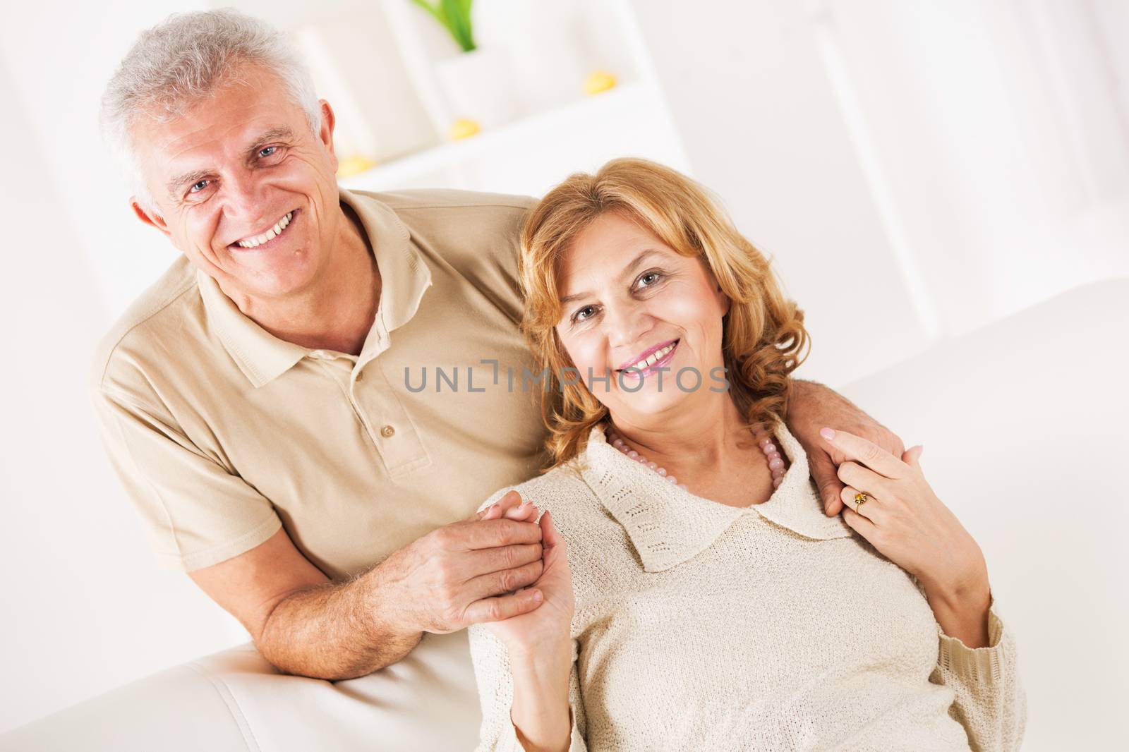 Hugging Senior couple in living room.