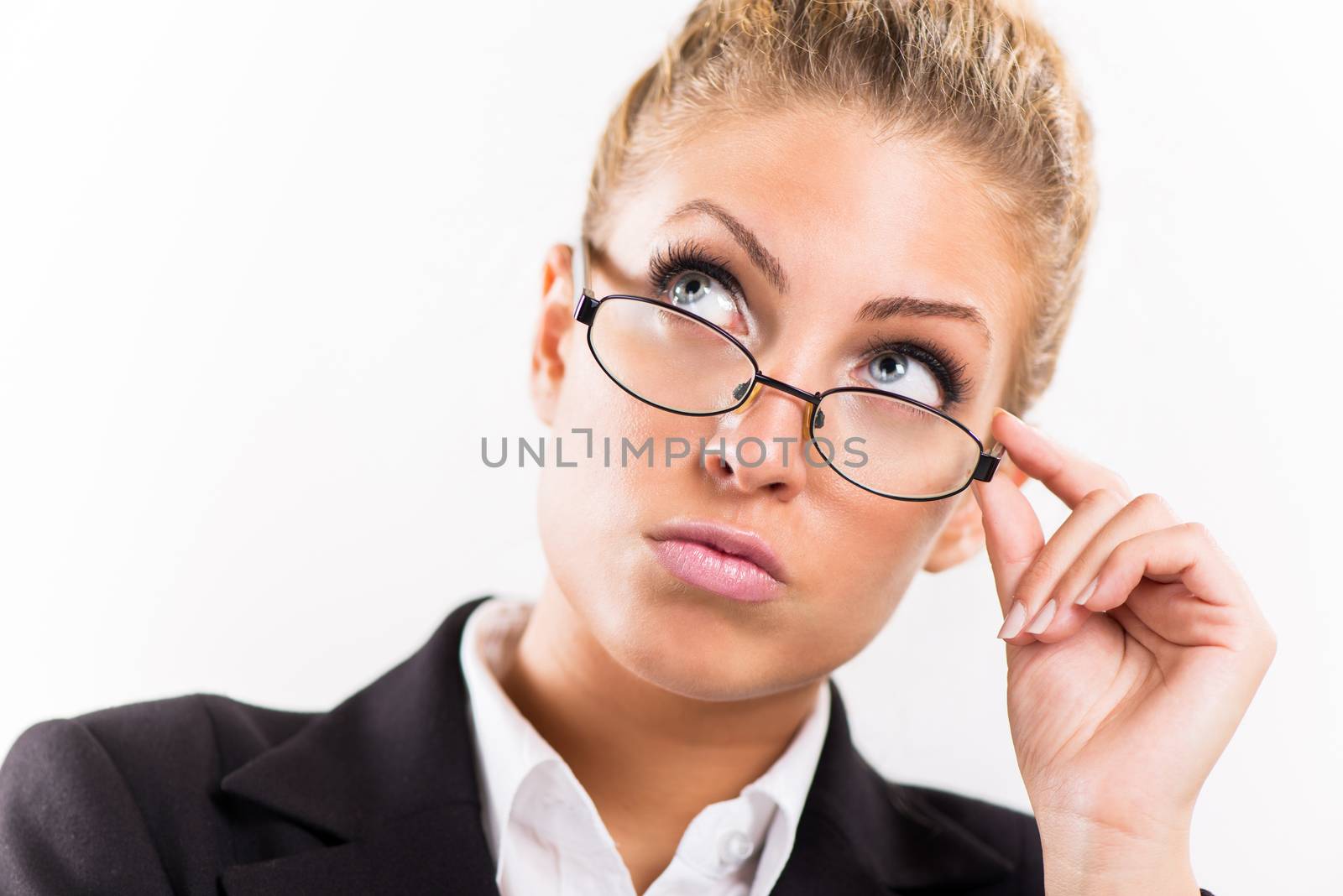 Portrait of attractive businesswoman with glasses. She is thinking and looking up.