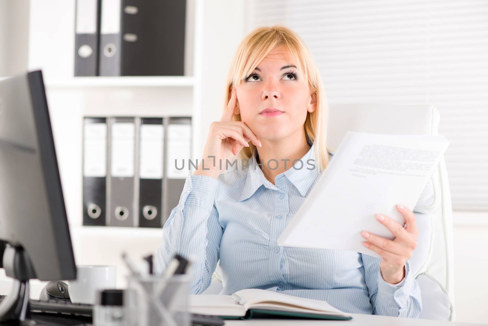 Businesswoman in the office. Sitting at the table and thinking.