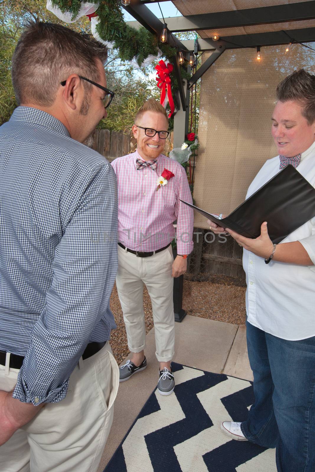Happy gay couple being married by justice of the peace