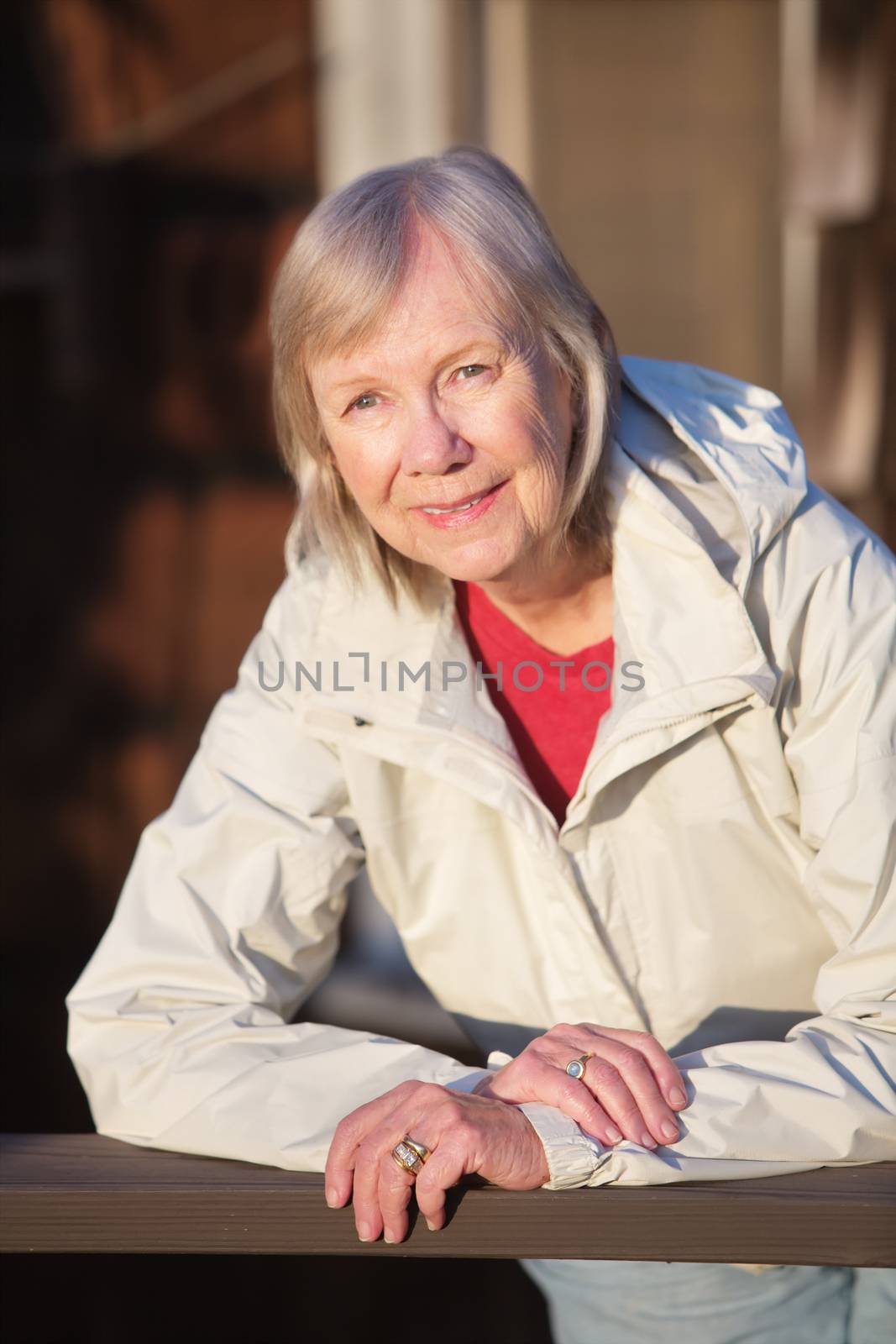 European smiling lady leaning on railing outdoors