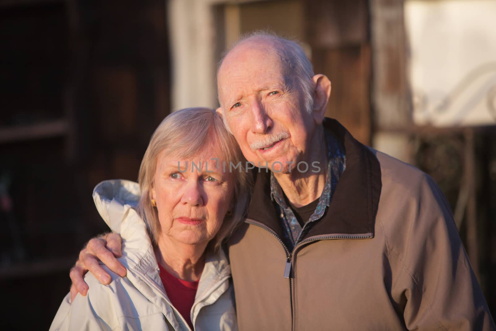 Serious European senior couple standing together outdoors