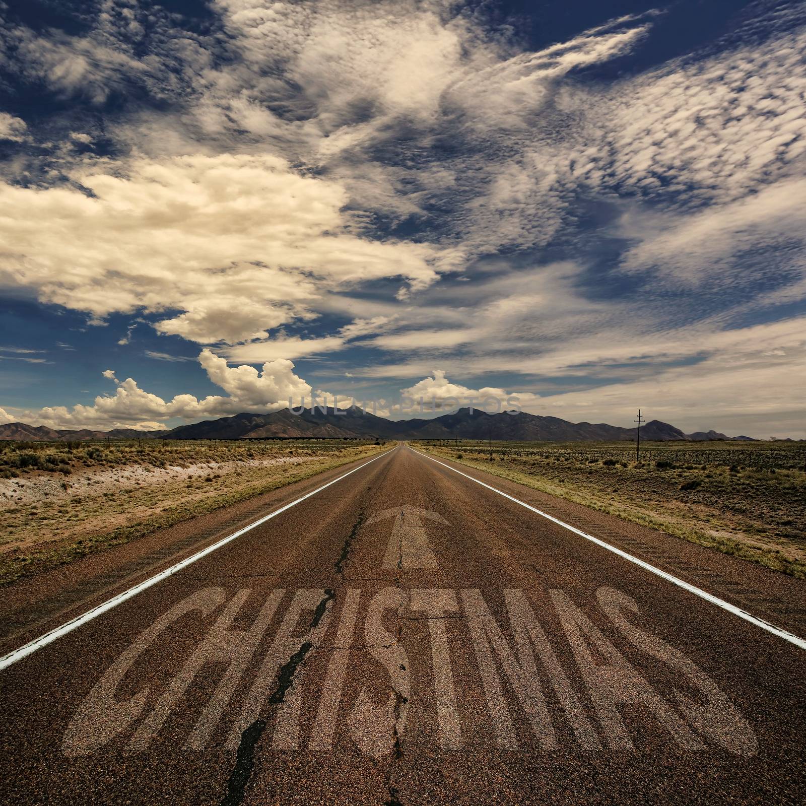 Conceptual image of desert road with the word Christmas and arrow