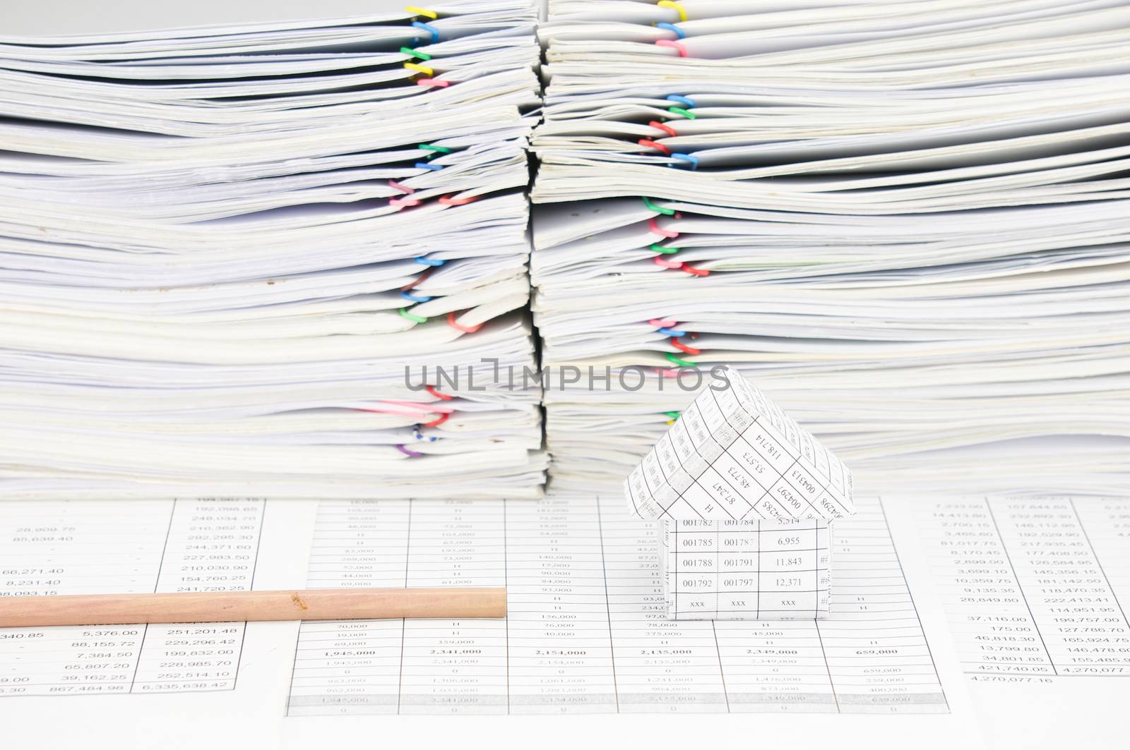 Bottom pencil and house on finance account have paper of report as background.