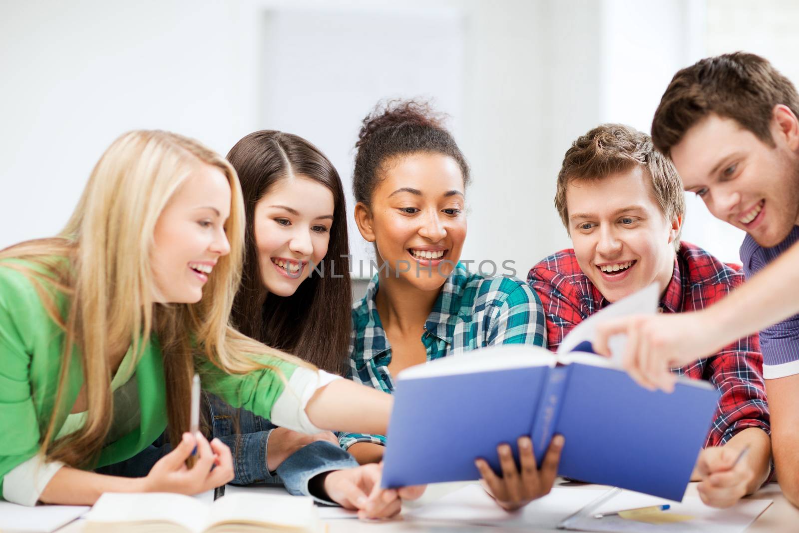 education concept - group of students reading book at school