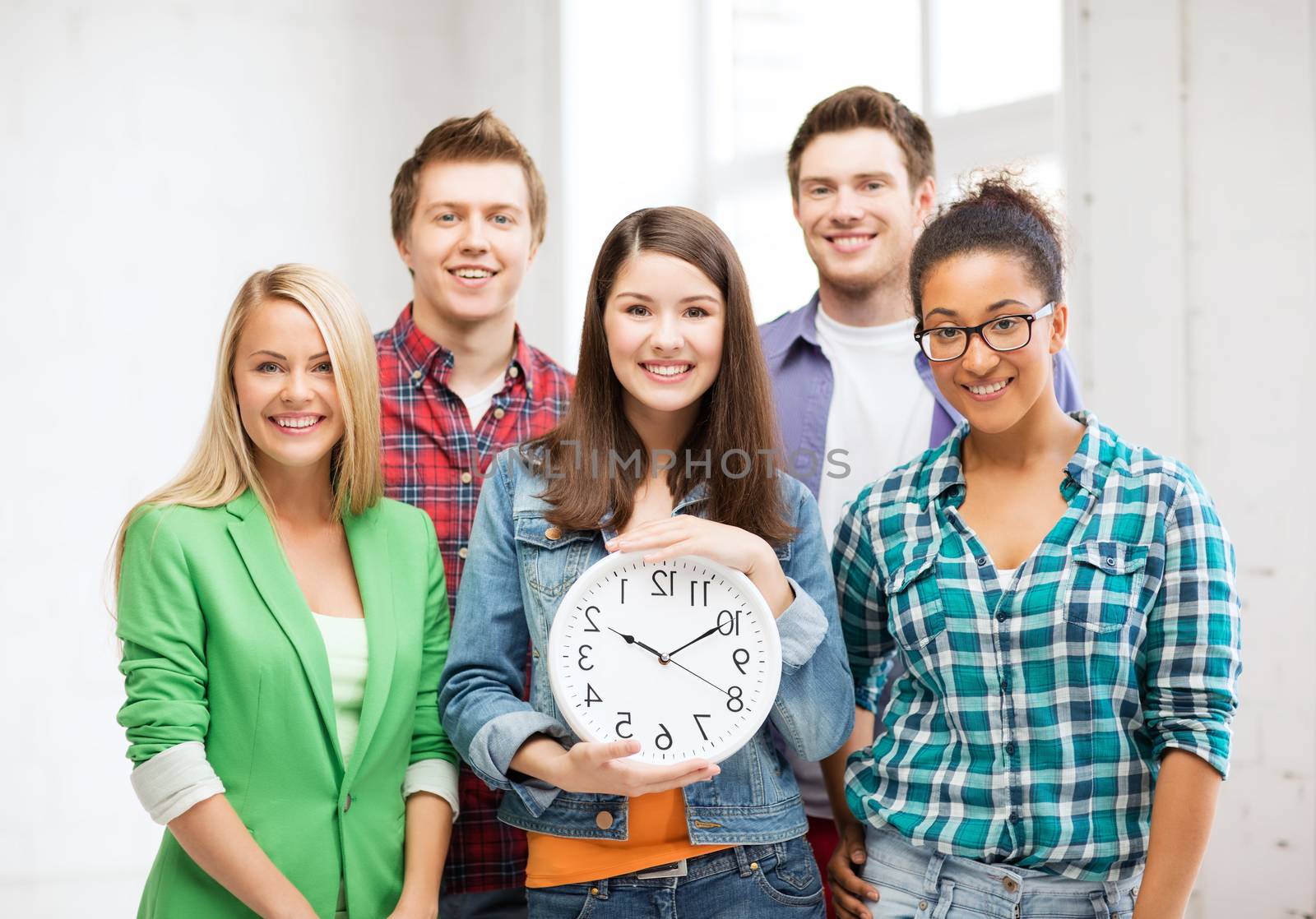 education and time concept - group of students at school with clock