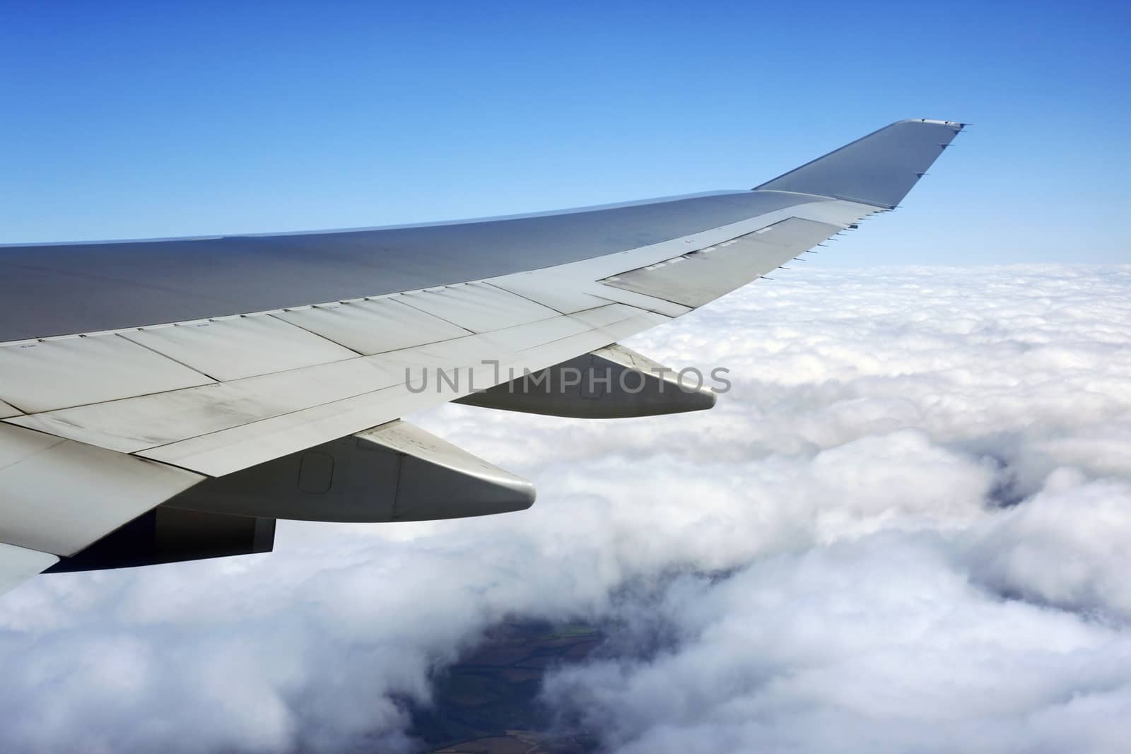 Wing of the plane on a background of clouds