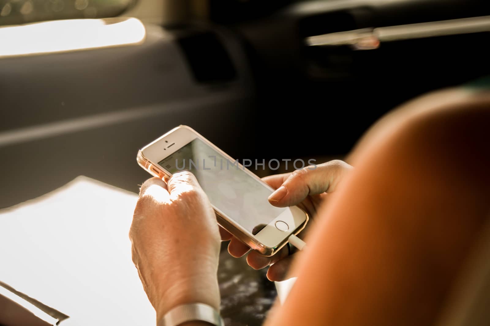 senior woman using her smartphone in car