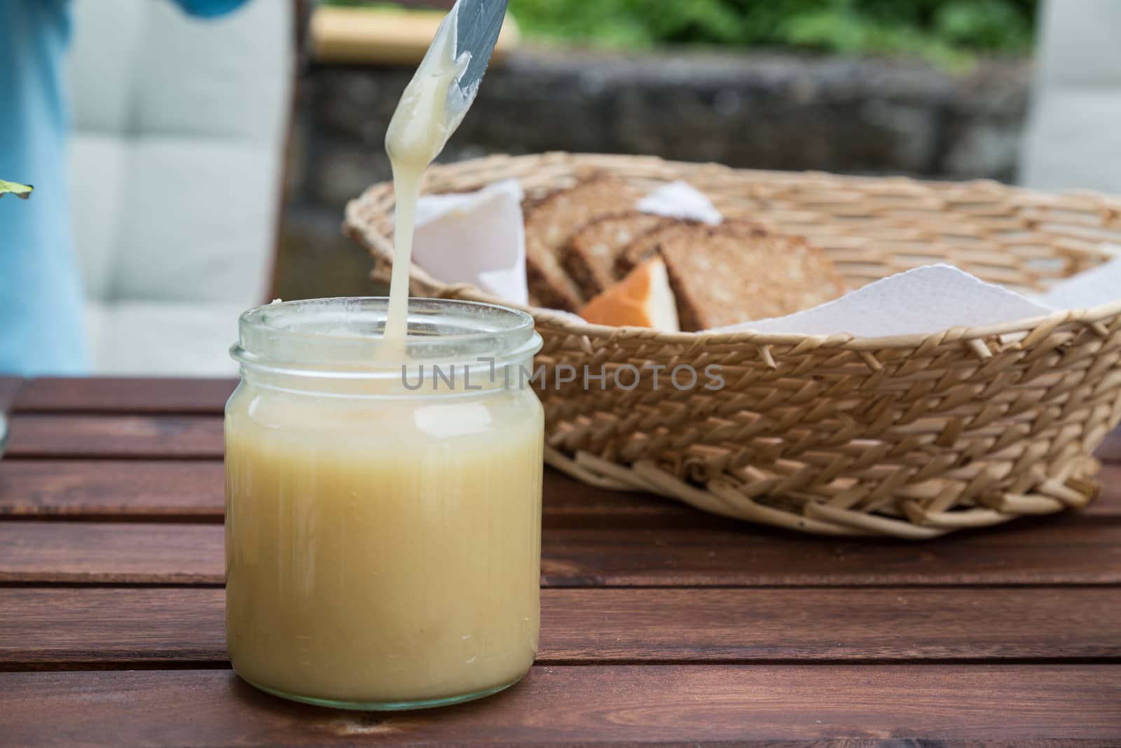 breakfast with honey. using a knife to get honey out of jar