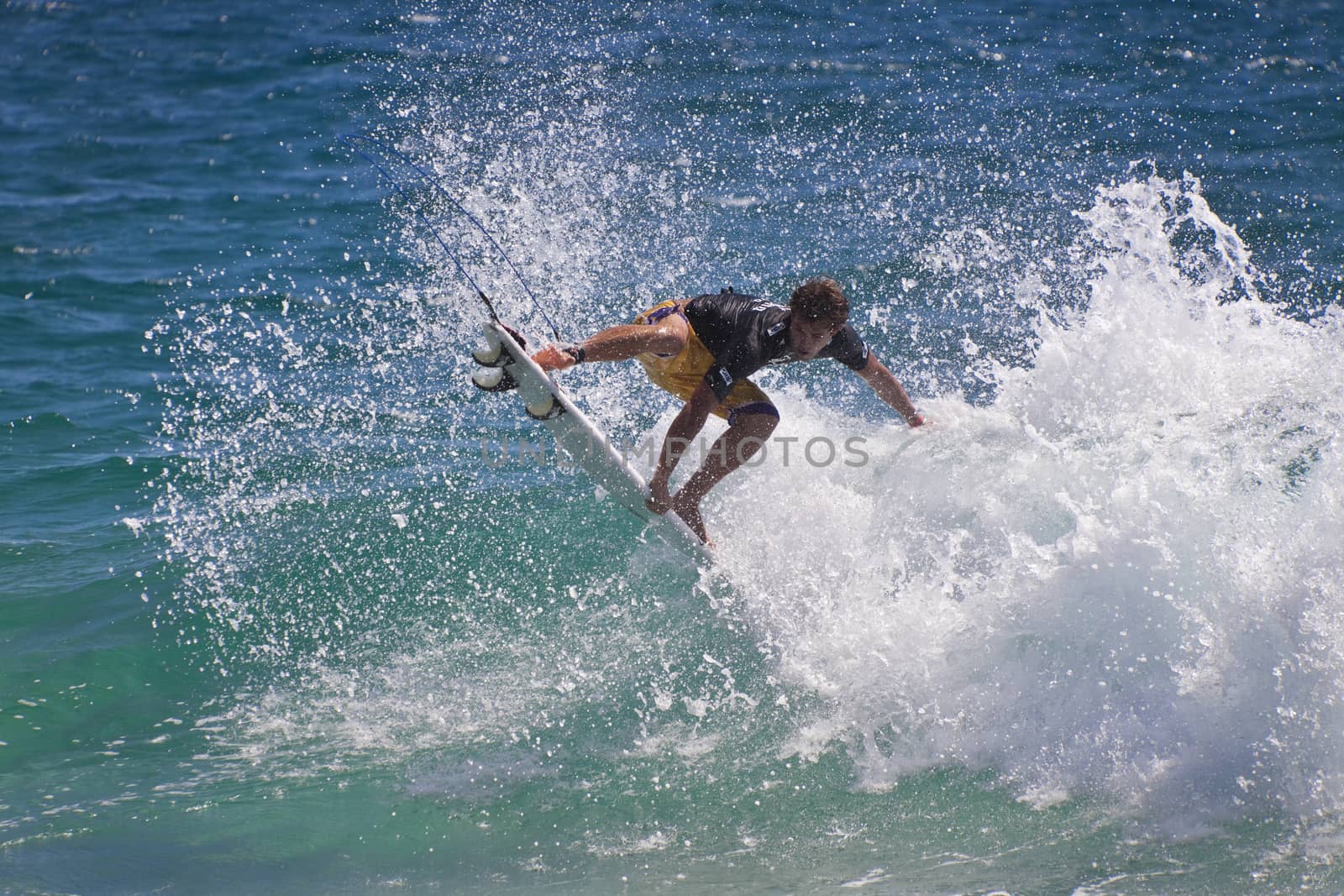 Surfer races the Quiksilver & Roxy Pro World Title Event. by Imagecom
