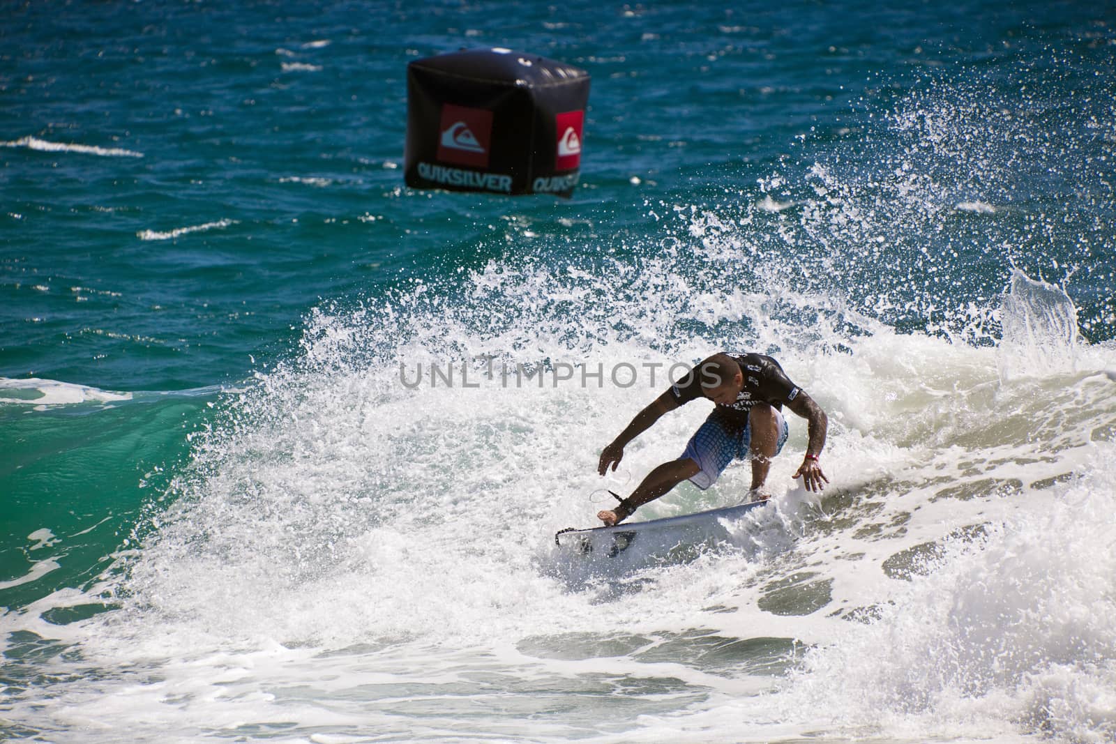 Surfer races the Quiksilver & Roxy Pro World Title Event. by Imagecom