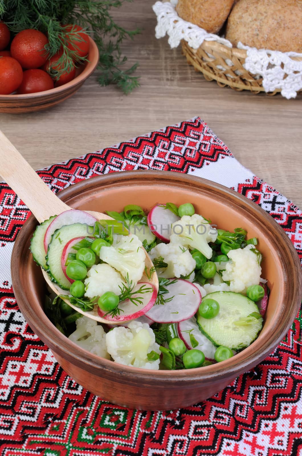 Cauliflower salad with cucumber, radish, peas and onions