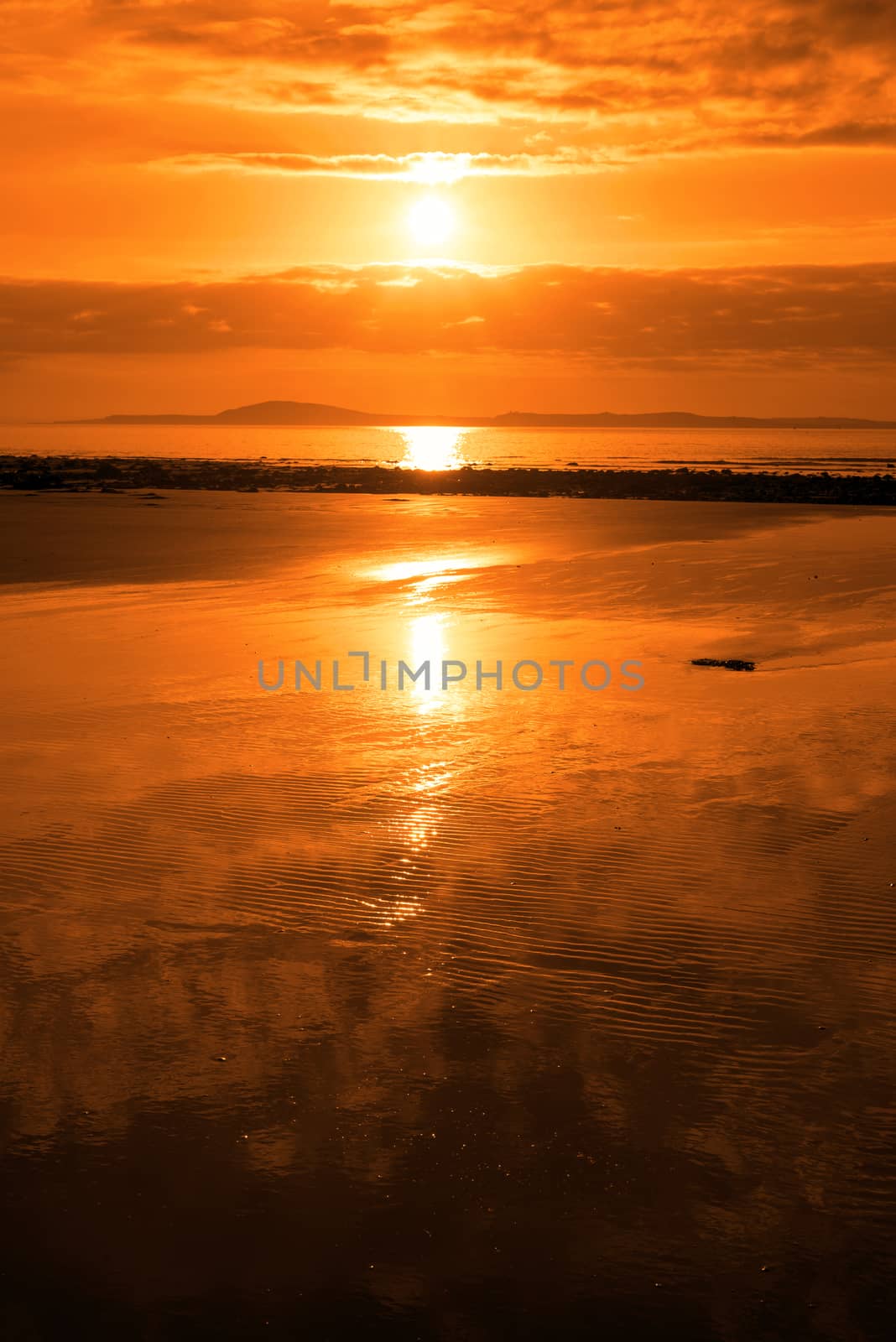 sunset and calm reflections at beal beach by morrbyte