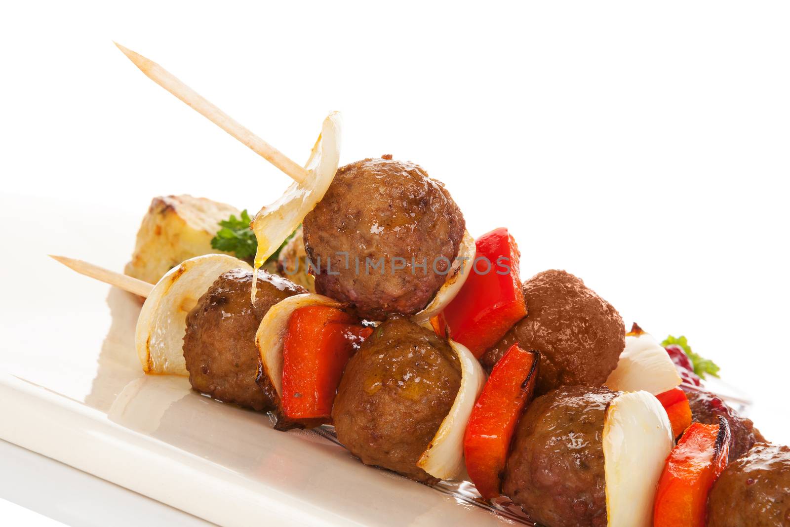 Meatball skewer with vegetable and smashed potatoes on ceramic tray isolated on white background. Culinary bbq eating. 