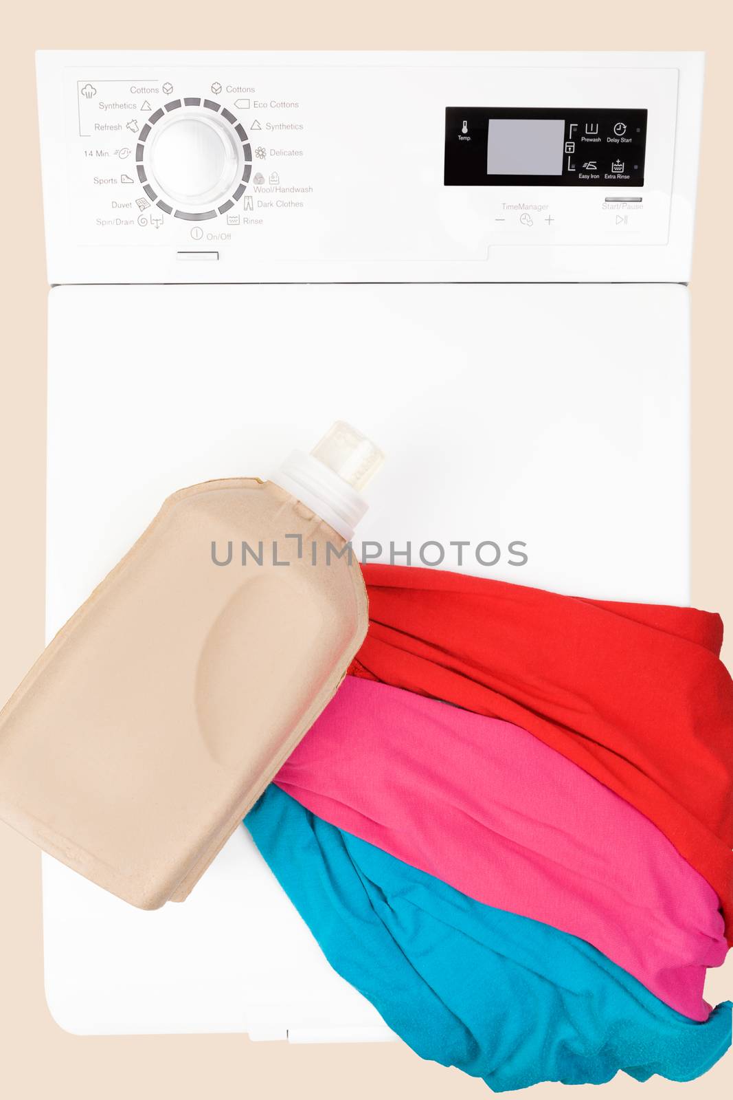 Laundry background. Top loading washing machine with natural organic detergent and colorful clothing top view.