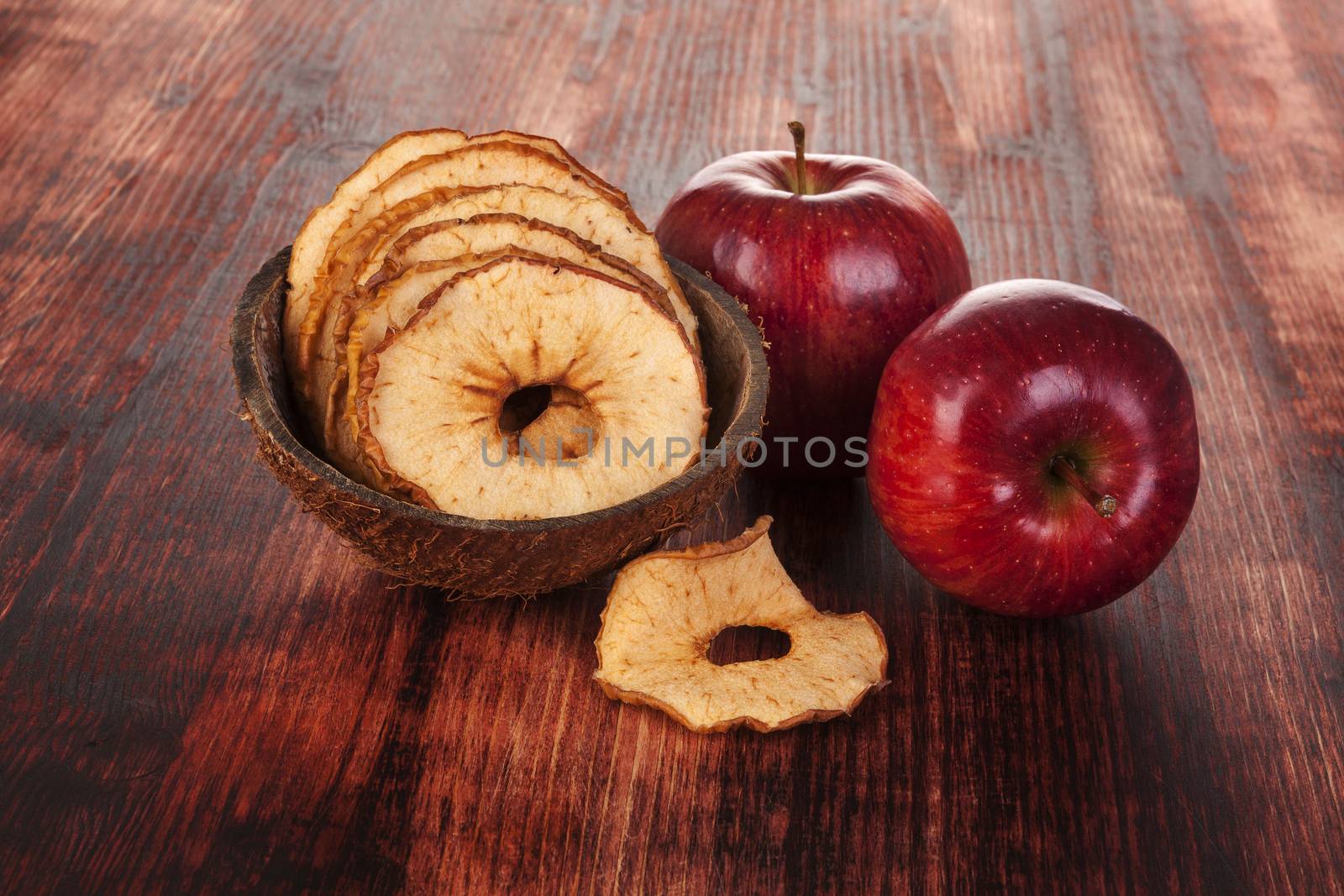 Dry and fresh apples on brown wooden table. Seasonal healthy snack eating.