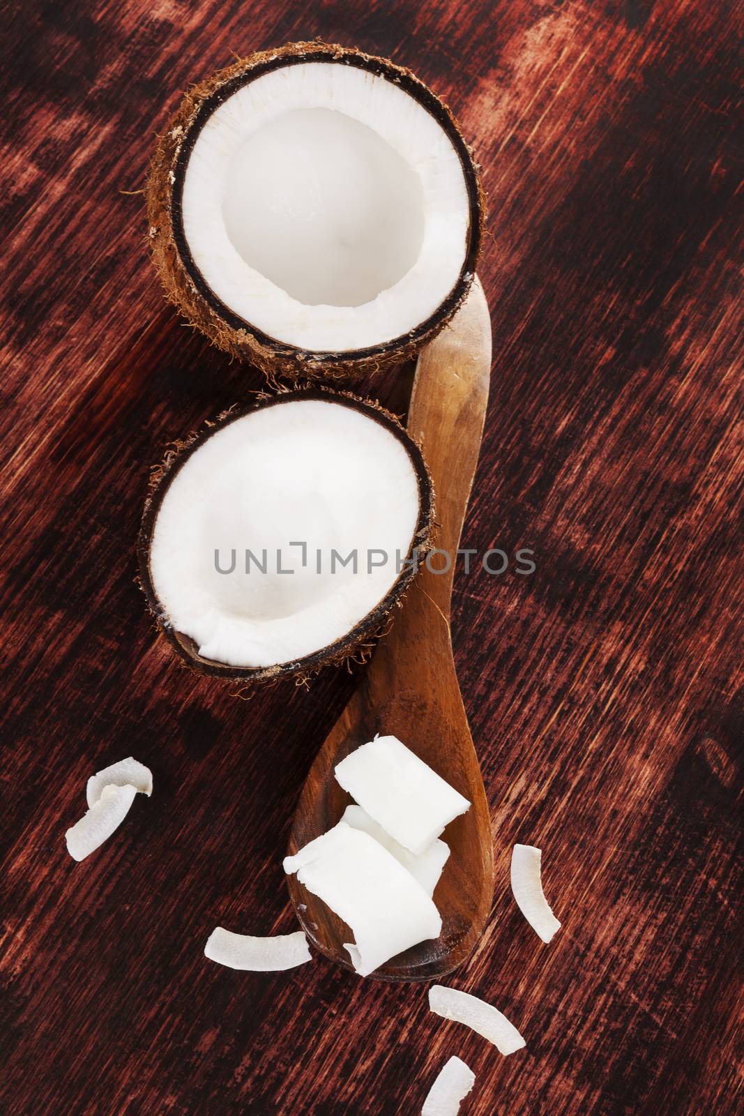 Coconut oil background. Hard coconut oil, coconut flakes and coconut on brown wooden background. Healthy ecological living.