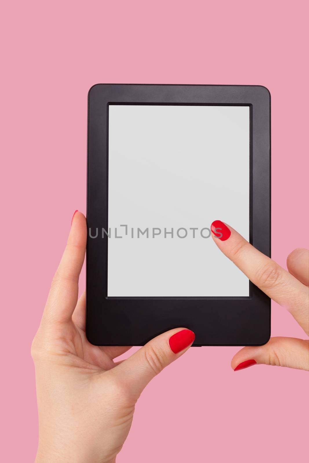 Female hand holding e reader isolated on pink background. Reading, education and learning concept. 