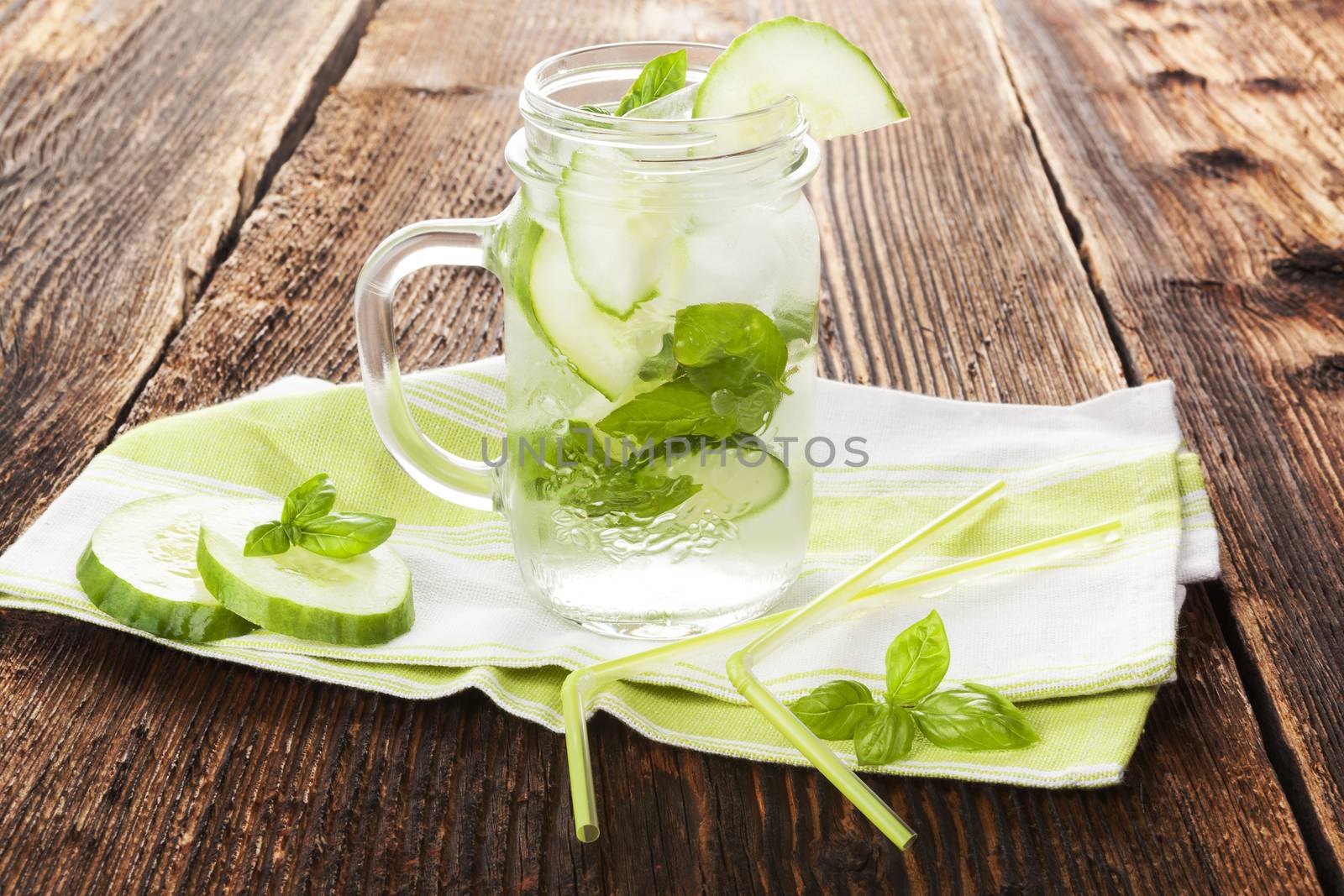 Cucumber basil lemonade on rustic wooden background. Healthy summer drink.