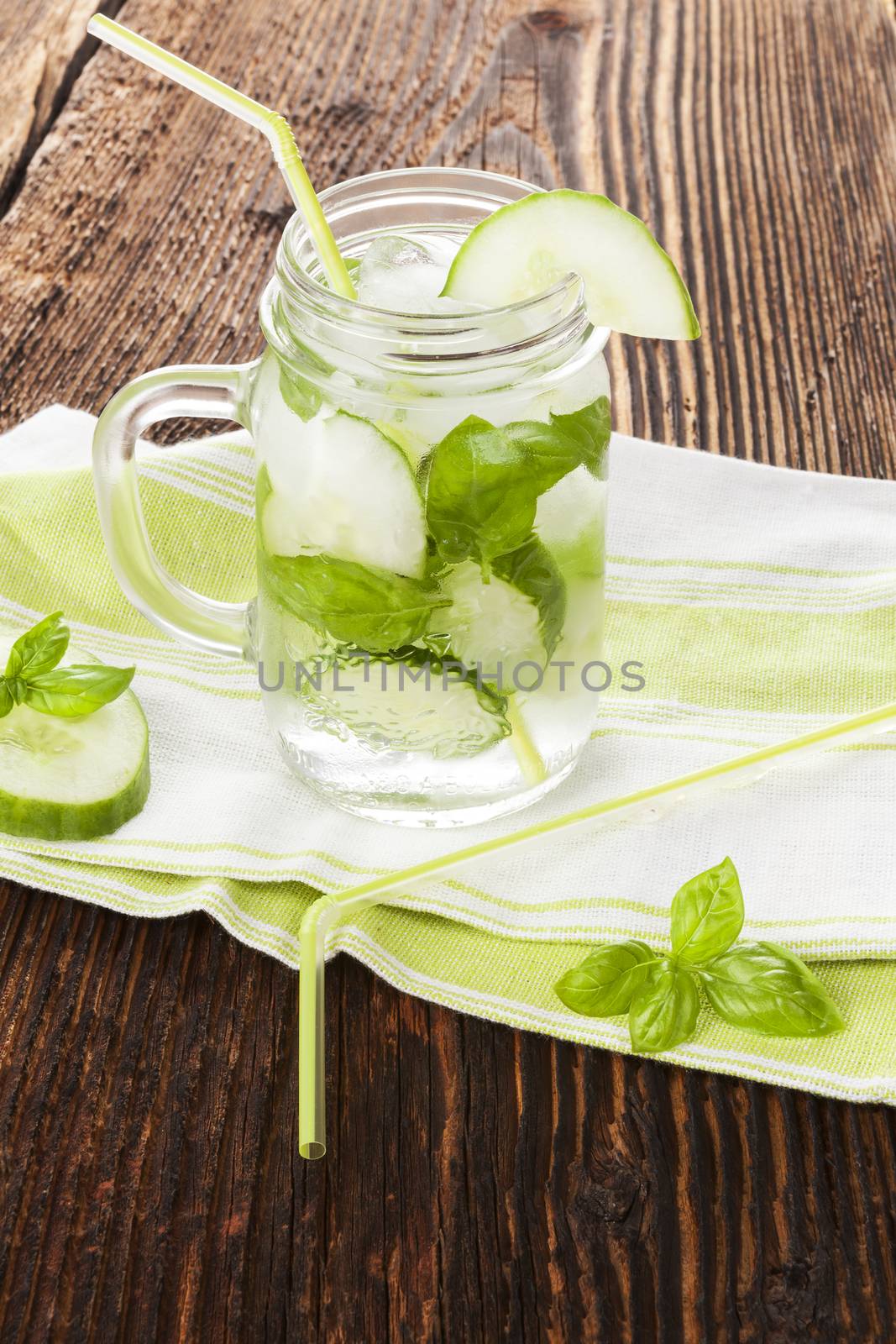 Cucumber basil lemonade on rustic wooden background. Healthy summer drink.