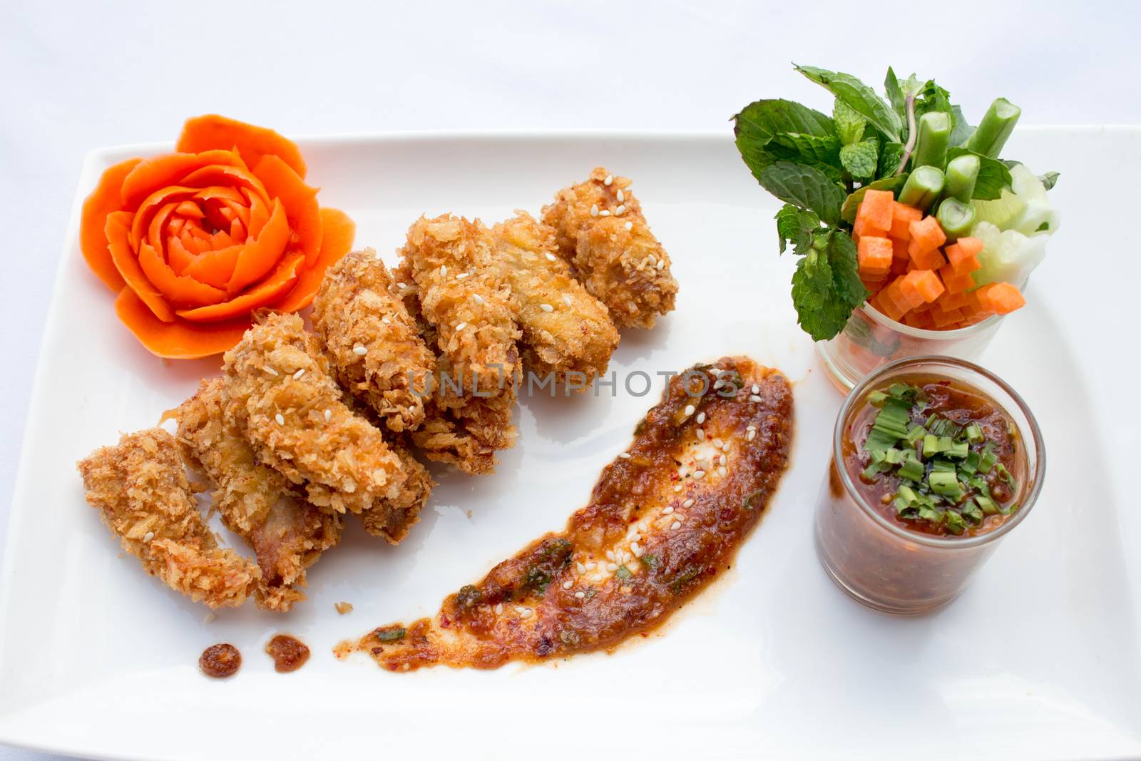 Tasty fried chicken and vegetable in white plates on white background .