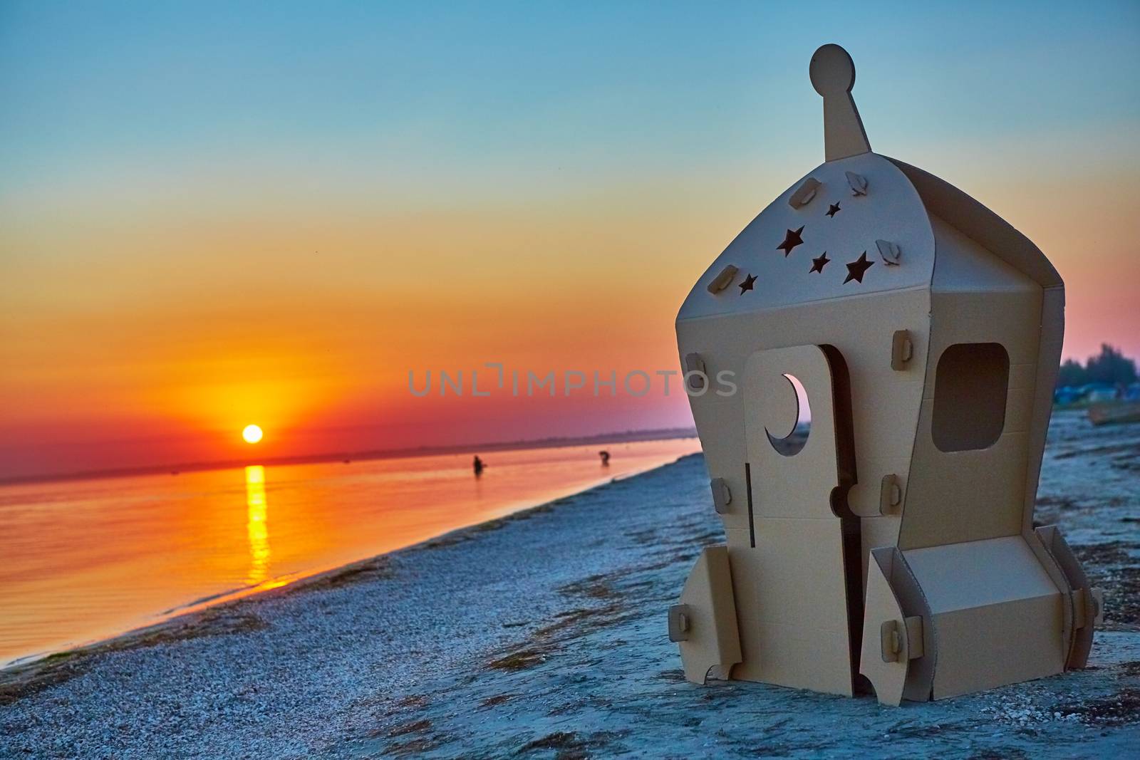 Cardboard toy spaceship at sea coast and sunset. by sarymsakov